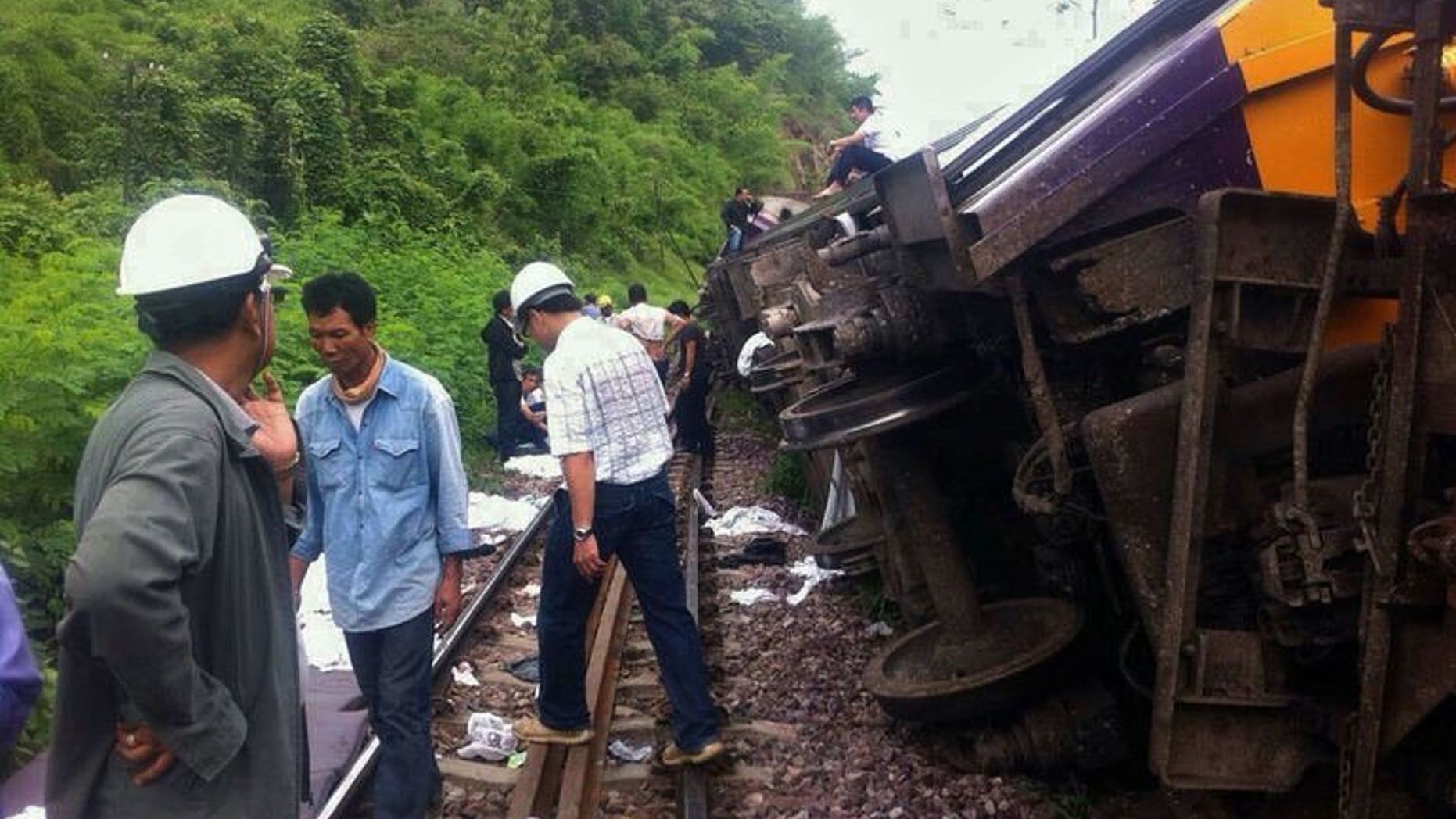 Rescue workers at the site of a Bangkok-Chiang Mai express service train that derailed from its tracks in Phrae province, northern Thailand on July 17, 2013. Foreign tourists were among 23 people injured when the overnight sleeper train derailed early Wednesday, the national rail operator said.