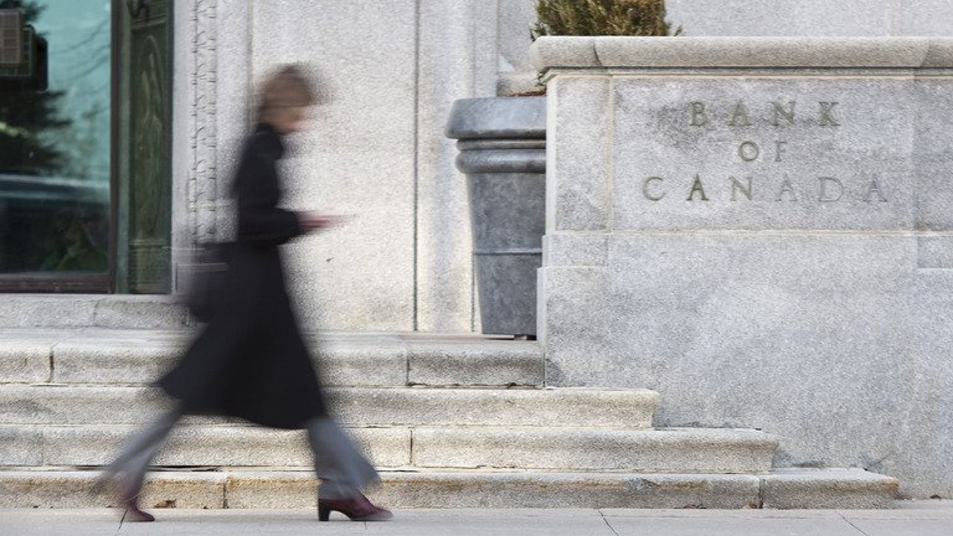 A woman walks past the Bank of Canada building in Ottawa on April 12, 2011. Canada's central bank held its key interest rate at 1.0 percent, while downgrading its global economic forecast