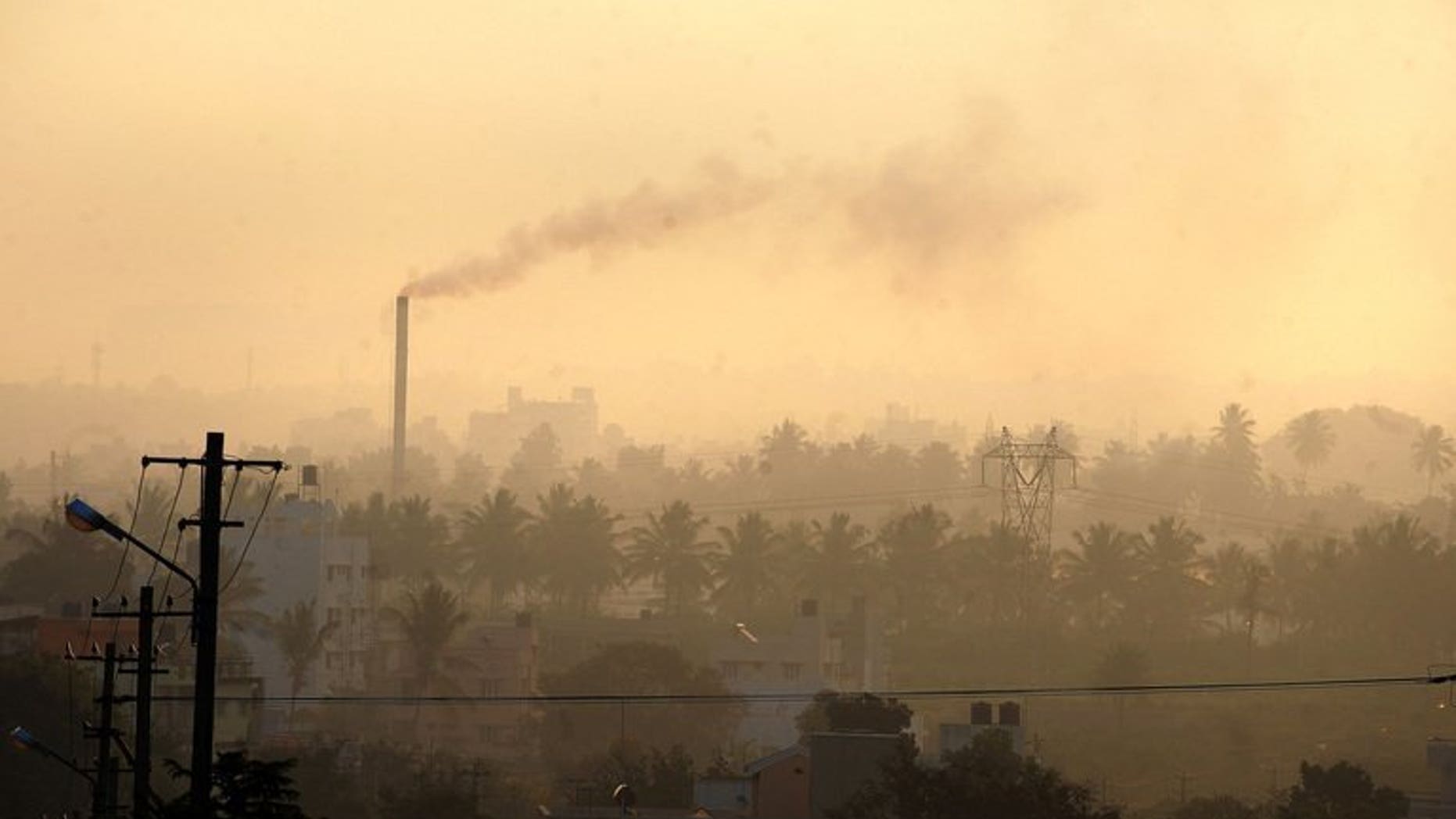 A factory chimney belches smoke in a residential area as haze casts a blanket over Bangalore, southern India on December 11, 2009. Pollution and other environmental degradation costs India $80 billion a year, nearly six percent of gross domestic product, the World Bank said in a report released on Wednesday.