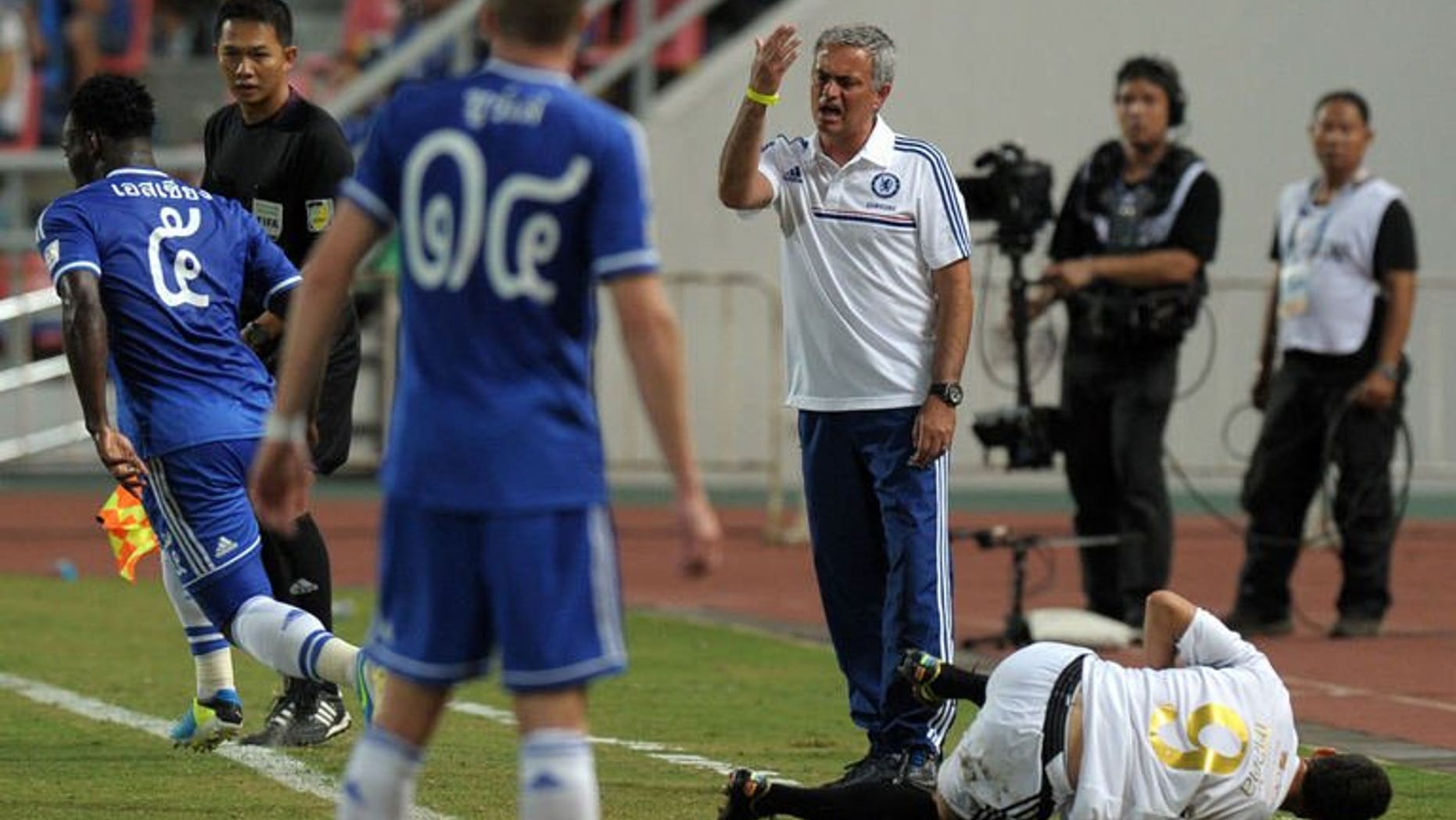 Chelsea football manager Jose Mourinho (C) gestures to his players as Cleiton Silva (R) of Singha All Star reacts during the exhibition match at Rajamangala National stadium in Bangkok on July 17, 2013. Chelsea beat Singha All Star 1-0.