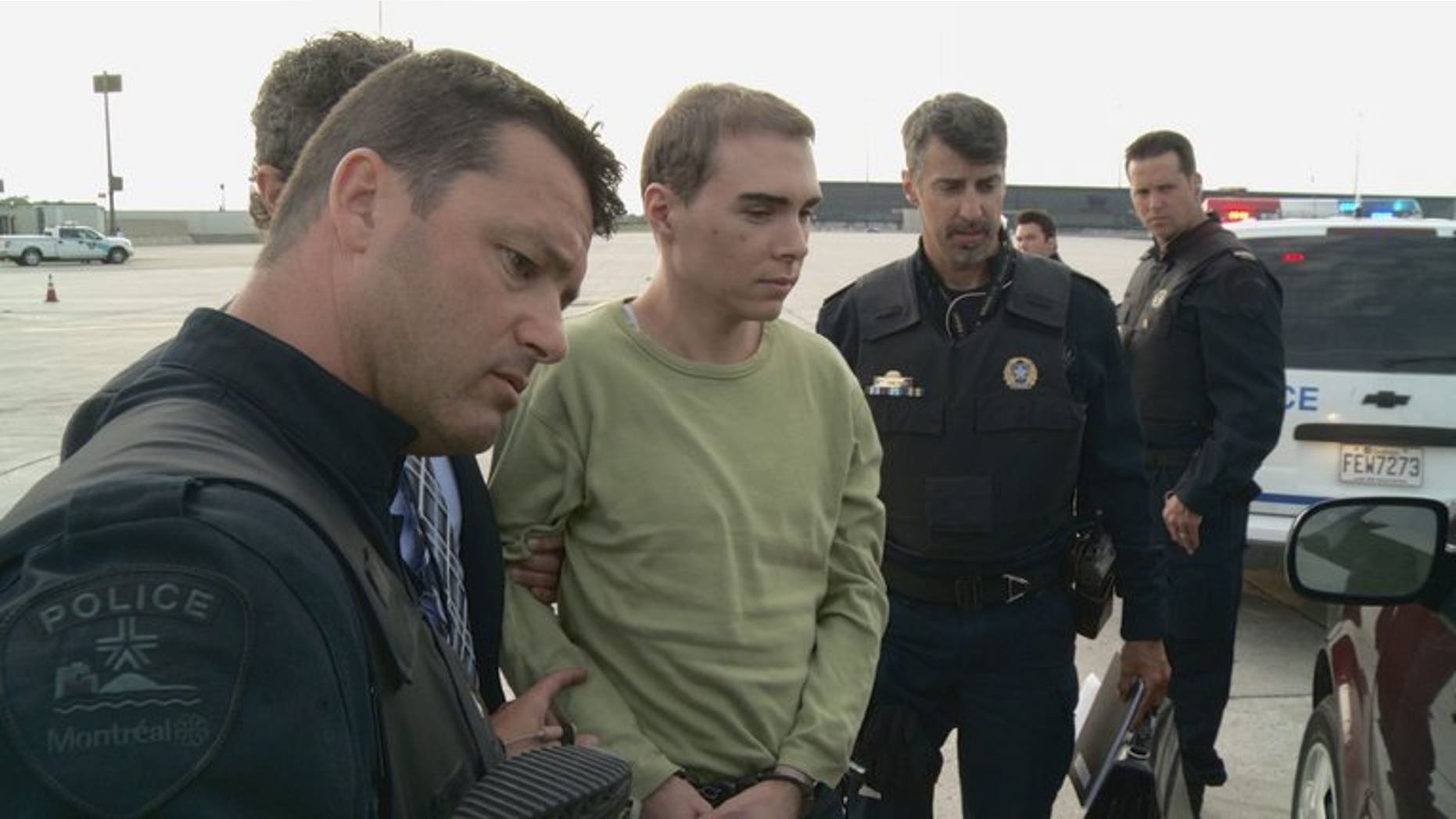 This photograph obtained courtesy of the Service de Police de la Ville de Montreal (SPVM) shows Luka Rocco Magnotta (C) escorted by police upon arrival from Germany on June 18, 2012.