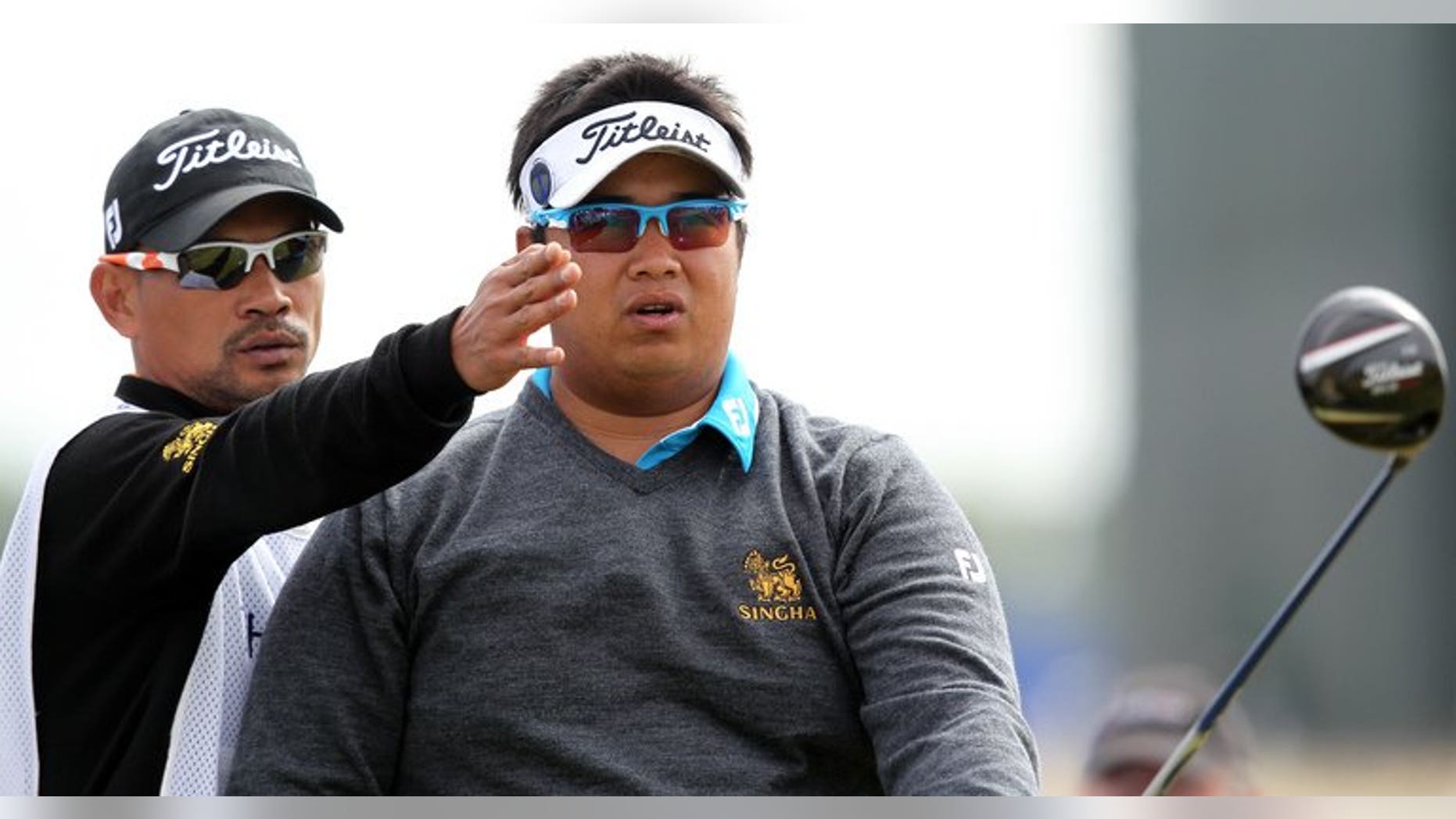 Thailand's Kiradech Aphibarnrat listens to his caddie before playing the 15th tee during the first round of the British Open at Muirfield golf course at Gullane in Scotland, on July 18, 2013. Kiradech battled to a one-over-par 72 after struggling with poor iron-play in the opening round of the British Open.