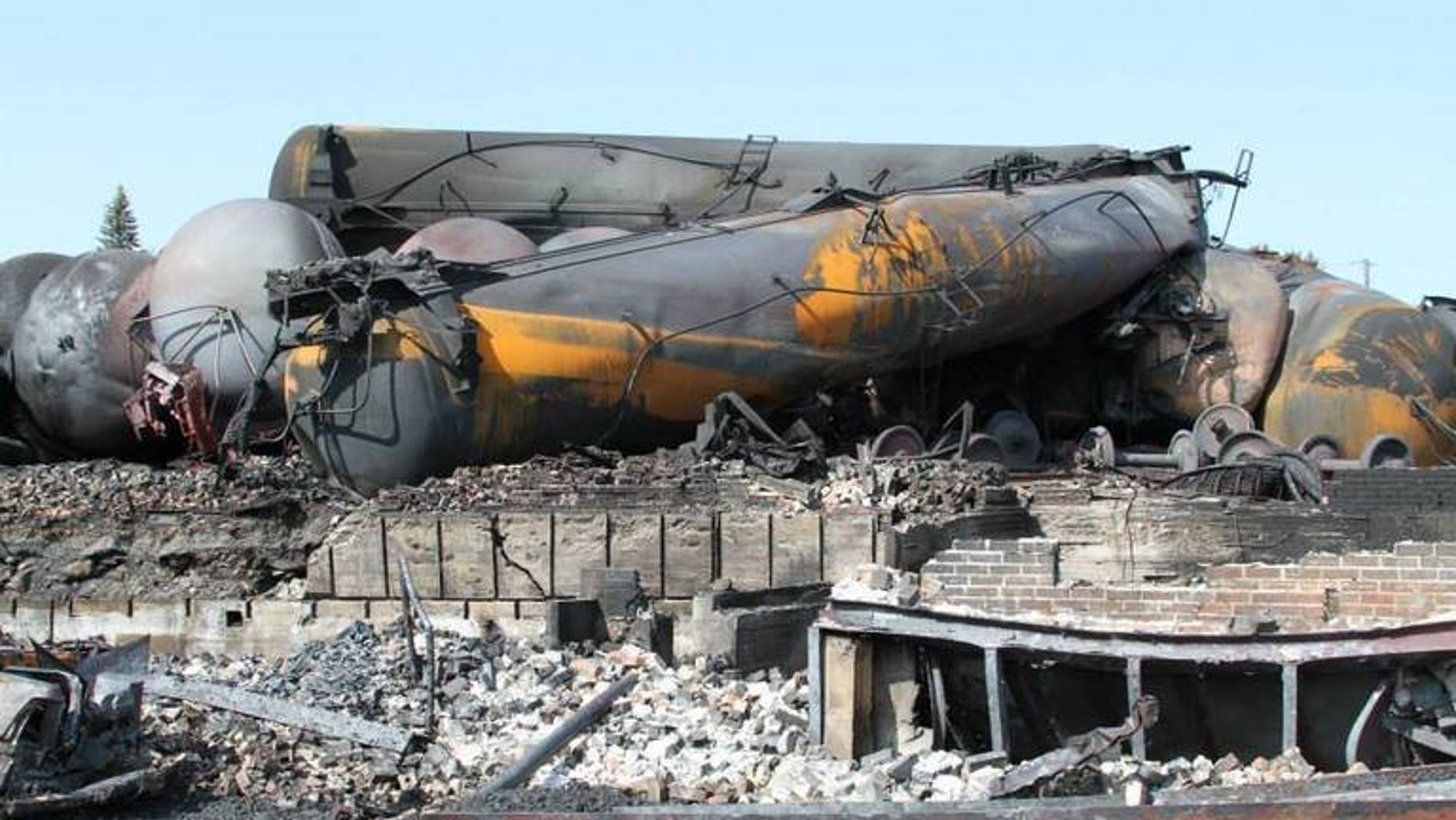This picture released by Quebec police (Surete du Quebec) on July 12, 2013 shows burnt train wagons in Lac-Megantic following the derailment and explosion of a train loaded with crude oil on July 6. Canada's two largest railways said they are reviewing procedures for securing stopped trains, pending new federal rules following the derailment of a runaway train in Quebec.