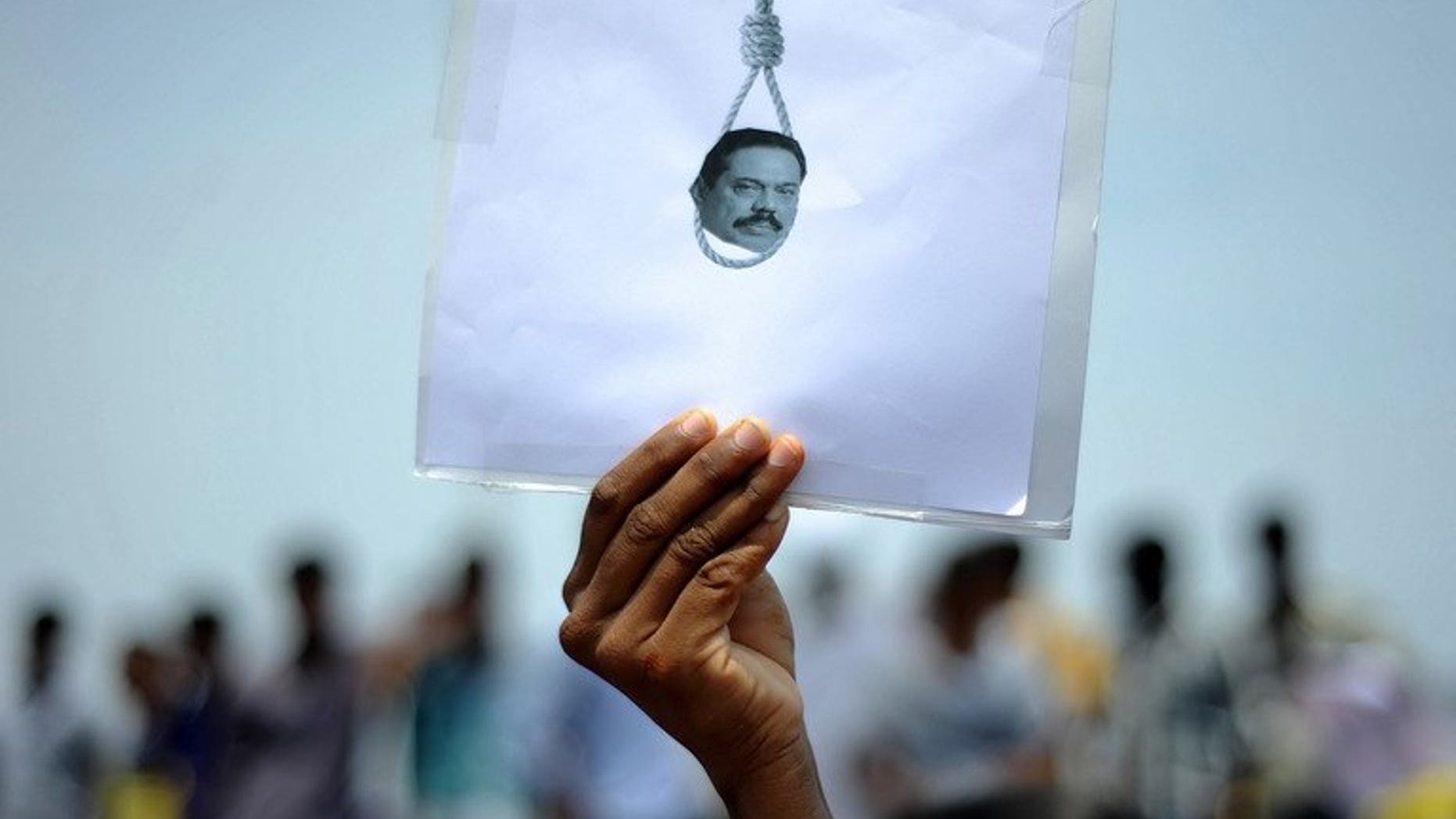 A student holds a poster featuring Sri Lanka's president in a protest over alleged war crimes against Tamils in Sri Lanka, in Chennai, India on March 20, 2013. European parliamentarians Friday asked Sri Lanka to deliver on promises to investigate allegations of war crimes and ensure ethnic reconciliation more than four years after crushing Tamil separatists.