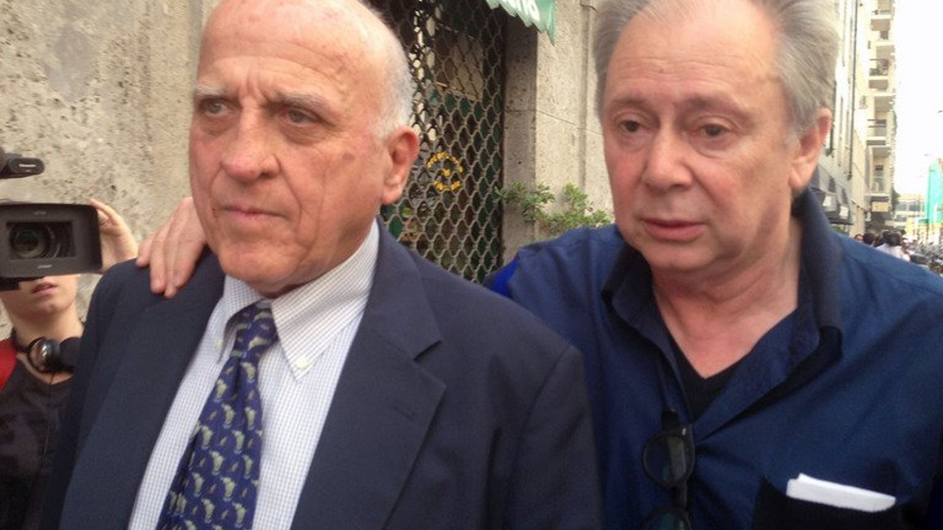 Italian entertainment agent Lele Mora (right) and his lawyer Gianluca Maris arrive at a court in Milan on July 19, 2013. A Milan court on Friday found three of Silvio Berlusconi's associates guilty of procuring prostitutes for racy parties held at the former Italian premier's Milan villa.