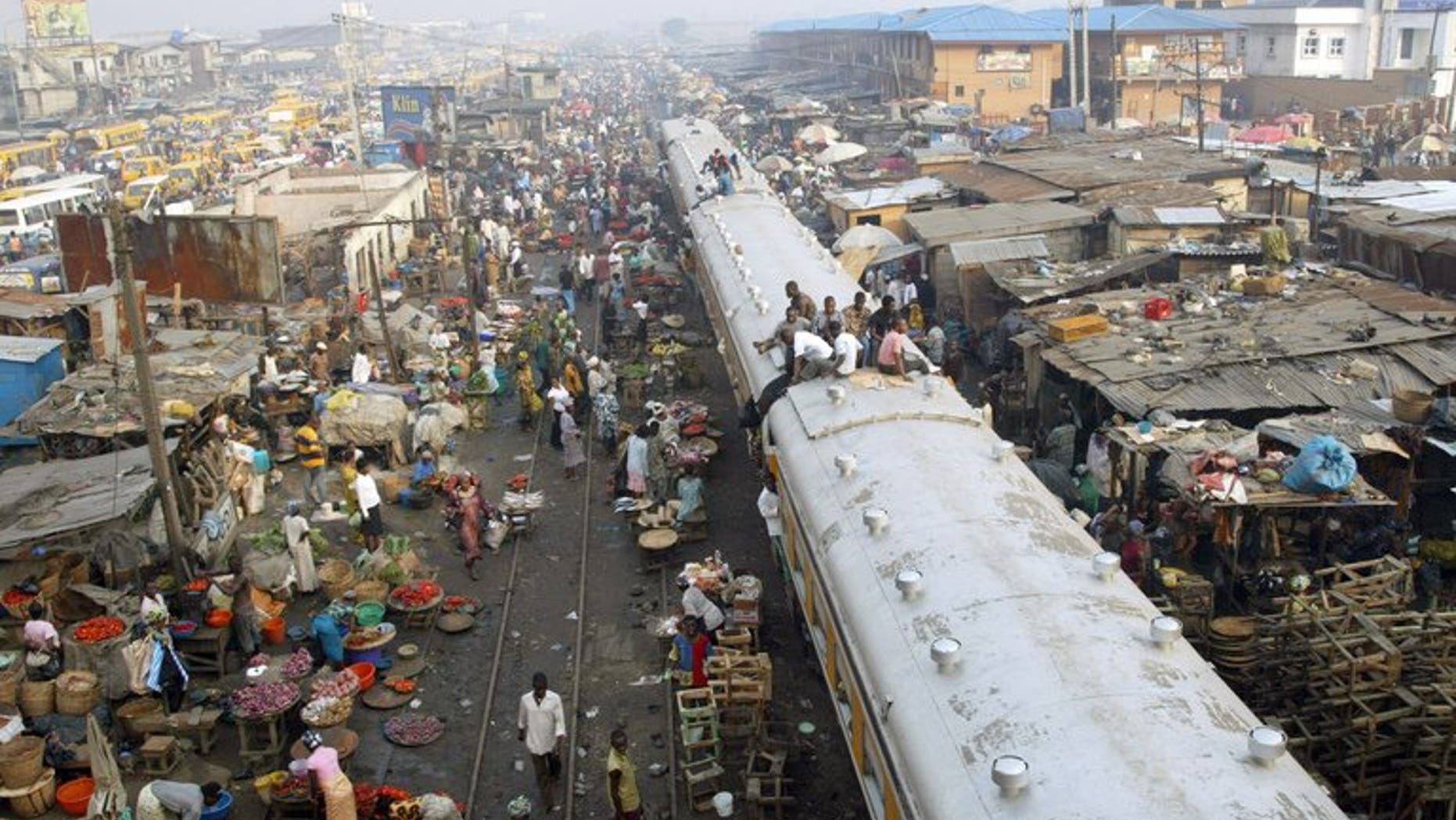 Commuters sit on coaches of a train chasing away vendors hawking their wares on the rail track in Oshodi district of Lagos on 16 November, 2007. A British national has been kidnapped by gunmen shortly after landing at the international airport in Lagos, Nigeria's largest city, a diplomat and a private security source told AFP Friday.