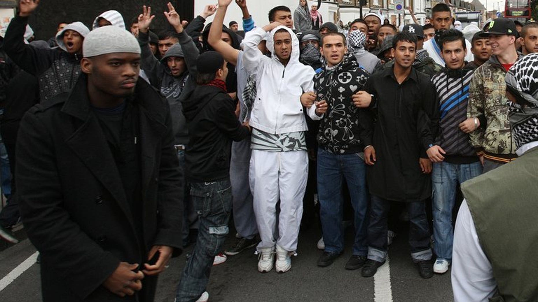 Michael Adebolajo (left) walks by a line of people near Harrow Mosque in London on September 11, 2009. Prison officers "strenuously deny any wrongdoing," their union said Friday, after Adebolajo lost two teeth when being restrained in jail.