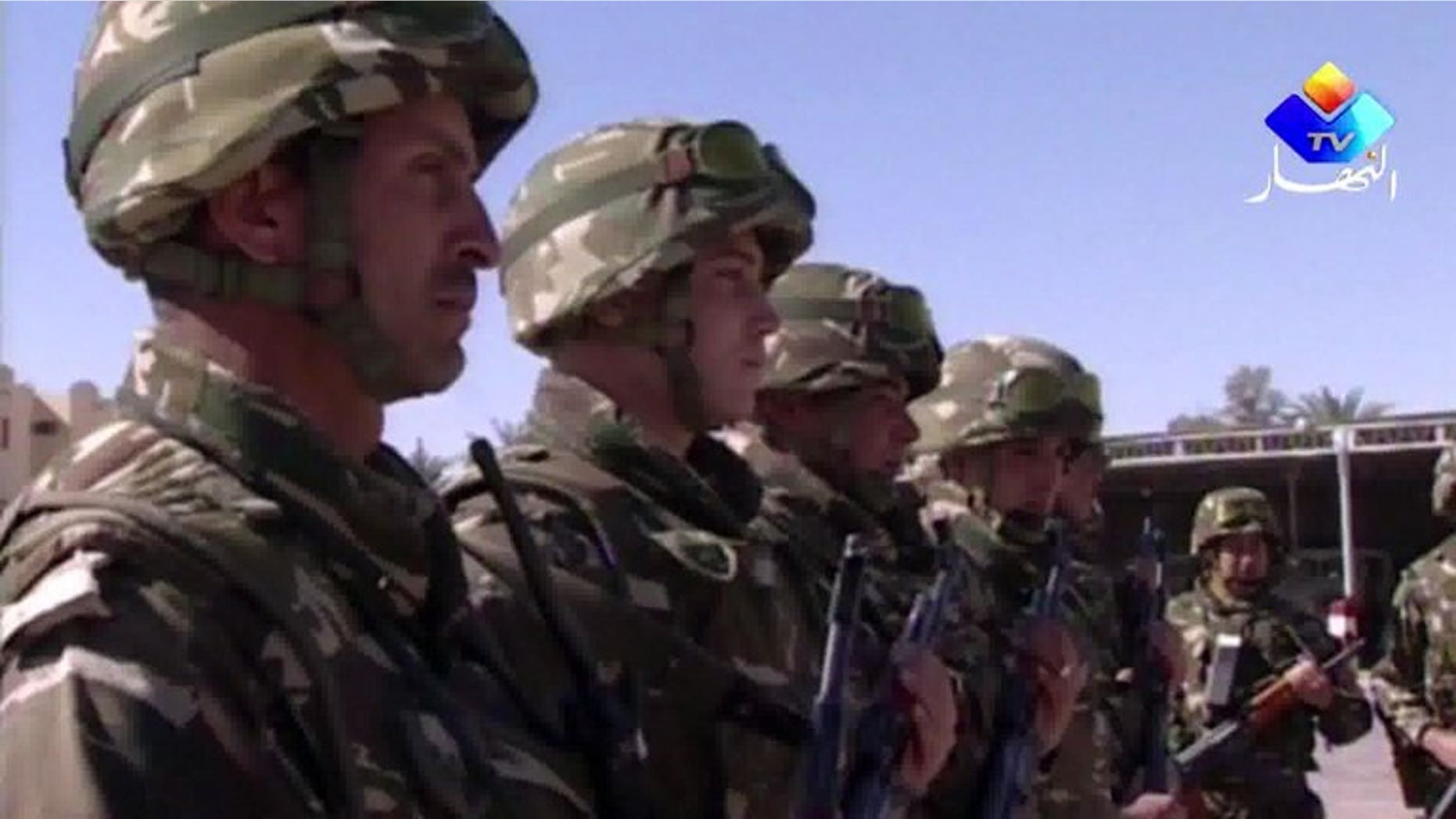 An image grab taken from footage provided by Algeria's Ennahar TV on January 18, 2013 and filmed in June 2012 shows Algerian soldiers standing to attention in the desert at an undisclosed location in the south of the country. Algerian soldiers shot dead four Islamists during an overnight raid in the town of Sour El-Ghozlane southeast of the capital Algiers, security sources said.