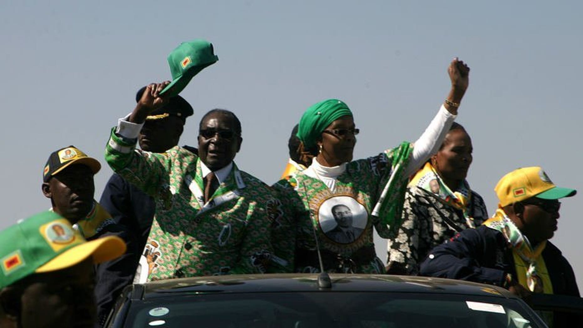 Zimbabwe's President Robert Mugabe (2nd L) waves as he arrives to address crowds gathered during an election campaign rally held at Chibuku Stadium, in Chitungwiza on July 16, 2013. Mugabe on Saturday warned South Africa's Jacob Zuma to stop his top mediator from commenting on the country's political crisis, as the veteran leader stepped up electioneering.