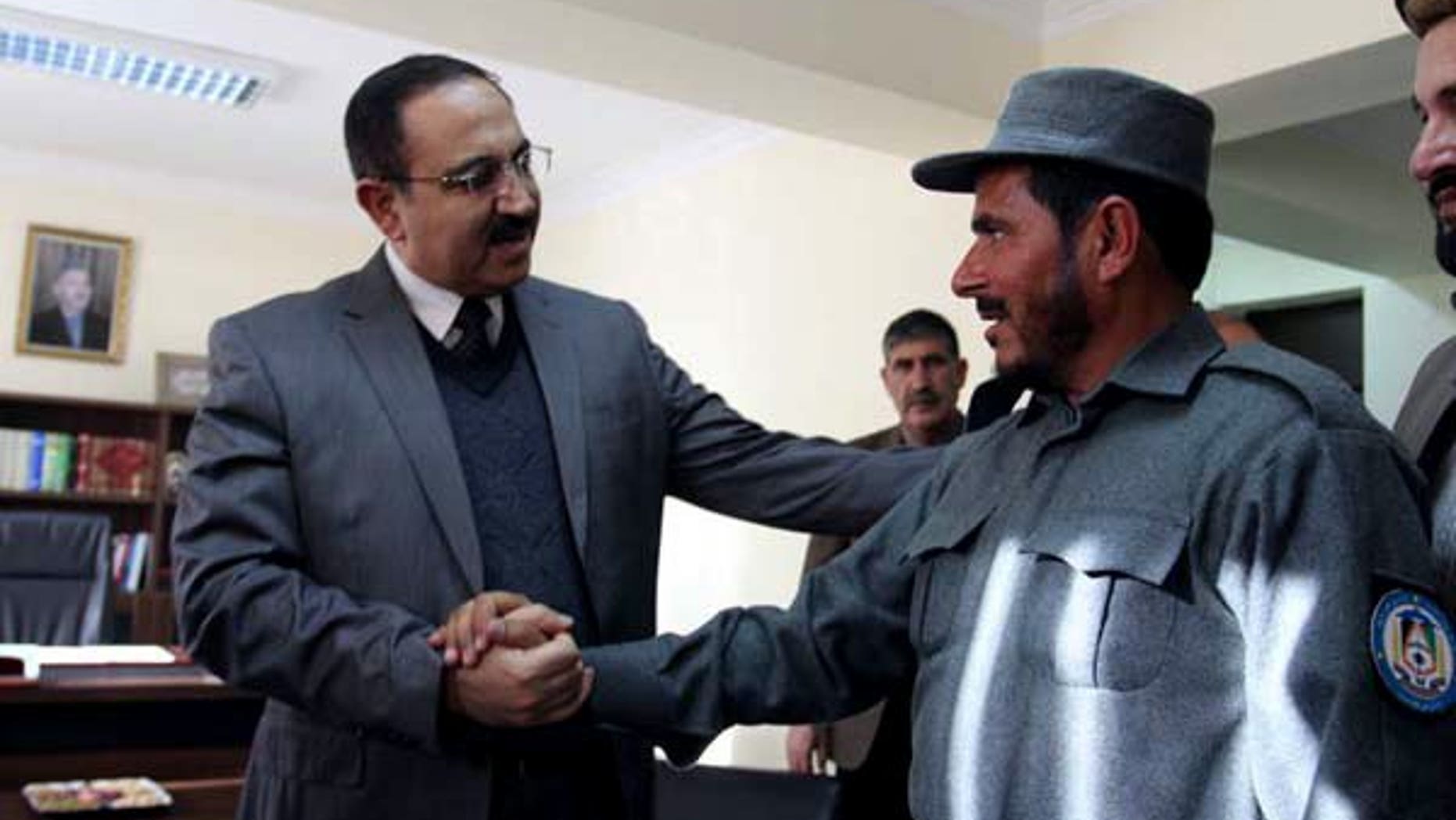 Afghanistan's Interior Minister Mujtaba Patang (left) speaks with a police officer in Kabul, on December 25, 2012. Afghanistan's parliament has sacked Patang -- one of the country's most powerful security chiefs -- less than a year after he took office.