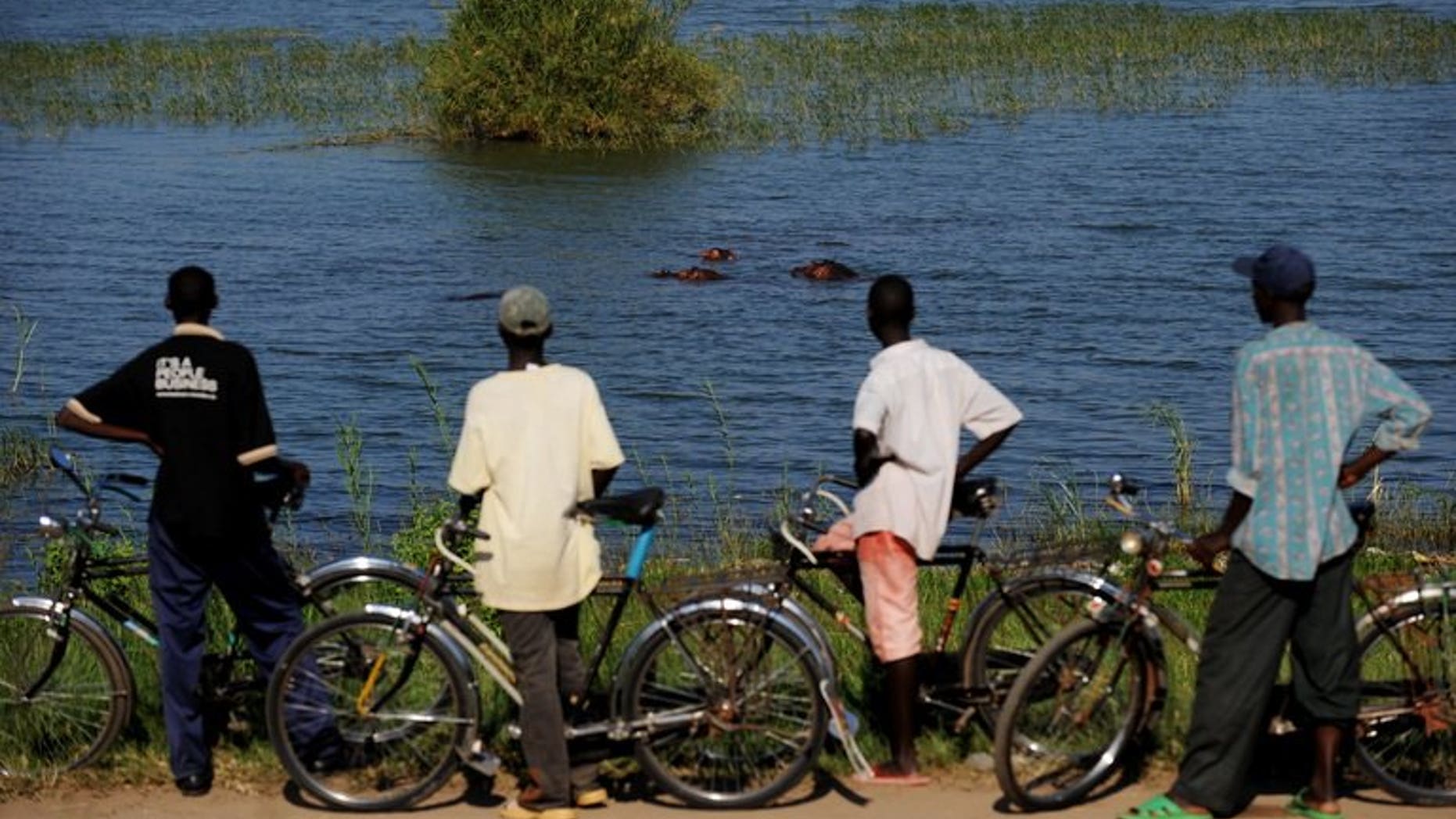 Burundian men look at a group of hippos wallowing in Lake Tanganyika on May 12, 2010. A cholera epidemic in Burundi, the longest in the small central African country's history, has killed at least 17 people in 10 months, a top health official told AFP.