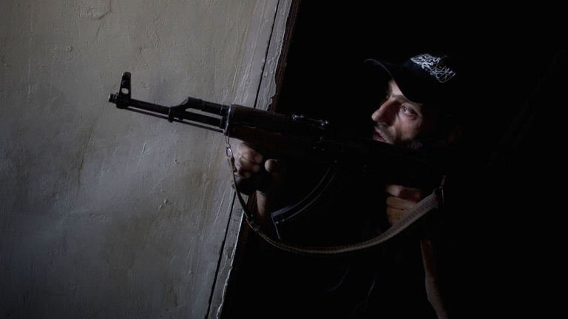 A Syrian rebel fighter points his gun towards pro-regime forces during clashes in the Salaheddine district of Aleppo, on July 9, 2013. Syria's rebels have seized the strategic town of Khan al-Assal, a regime bastion situated in the northern province of Aleppo, according to the Syrian Observatory for Human Rights.