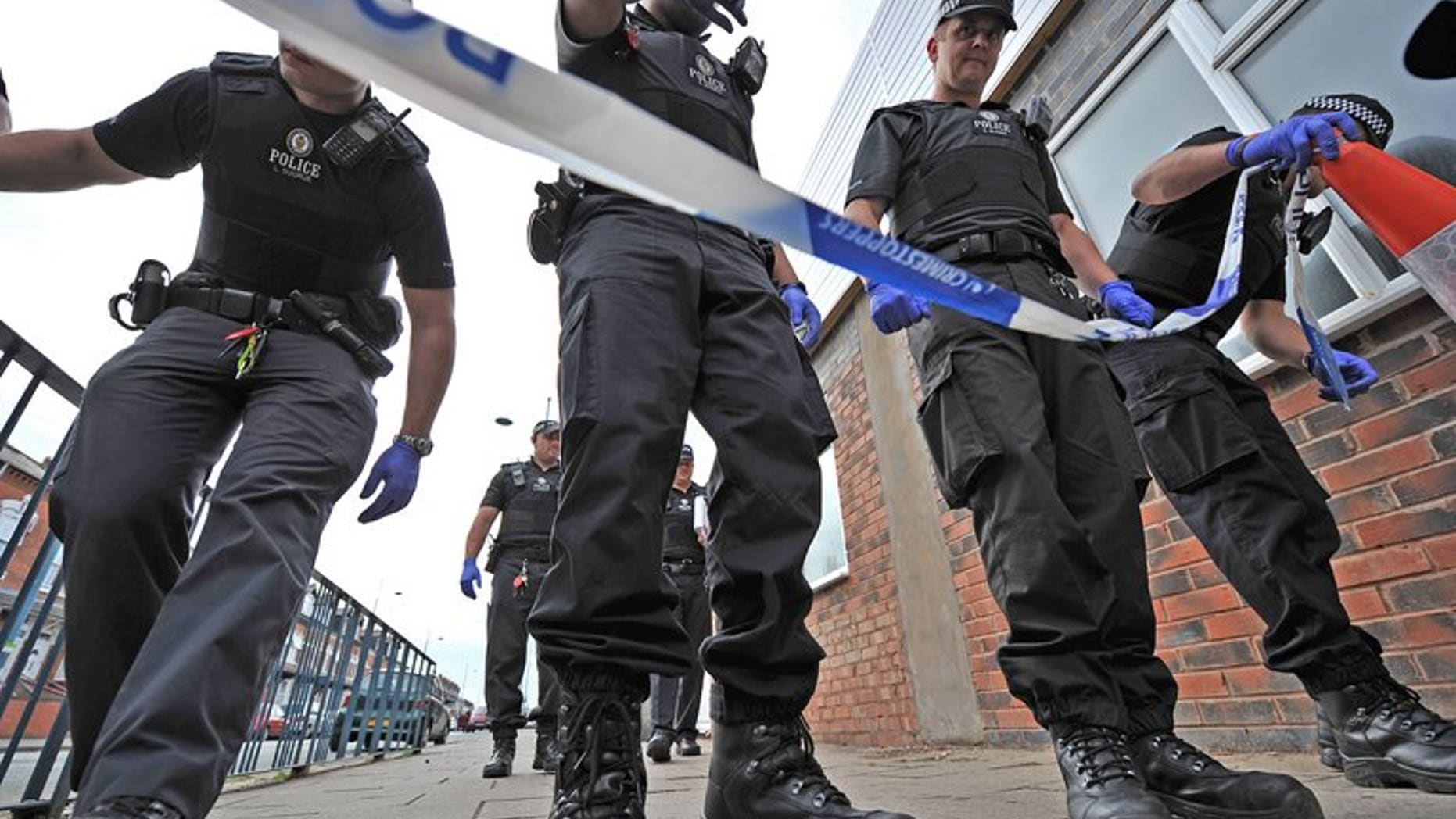 Police officers search a crime scene in Birmingham on August 10, 2011. British police on Monday charged a Ukranian man with the "terrorist-related" murder of an elderly Muslim man who was walking home from a mosque.