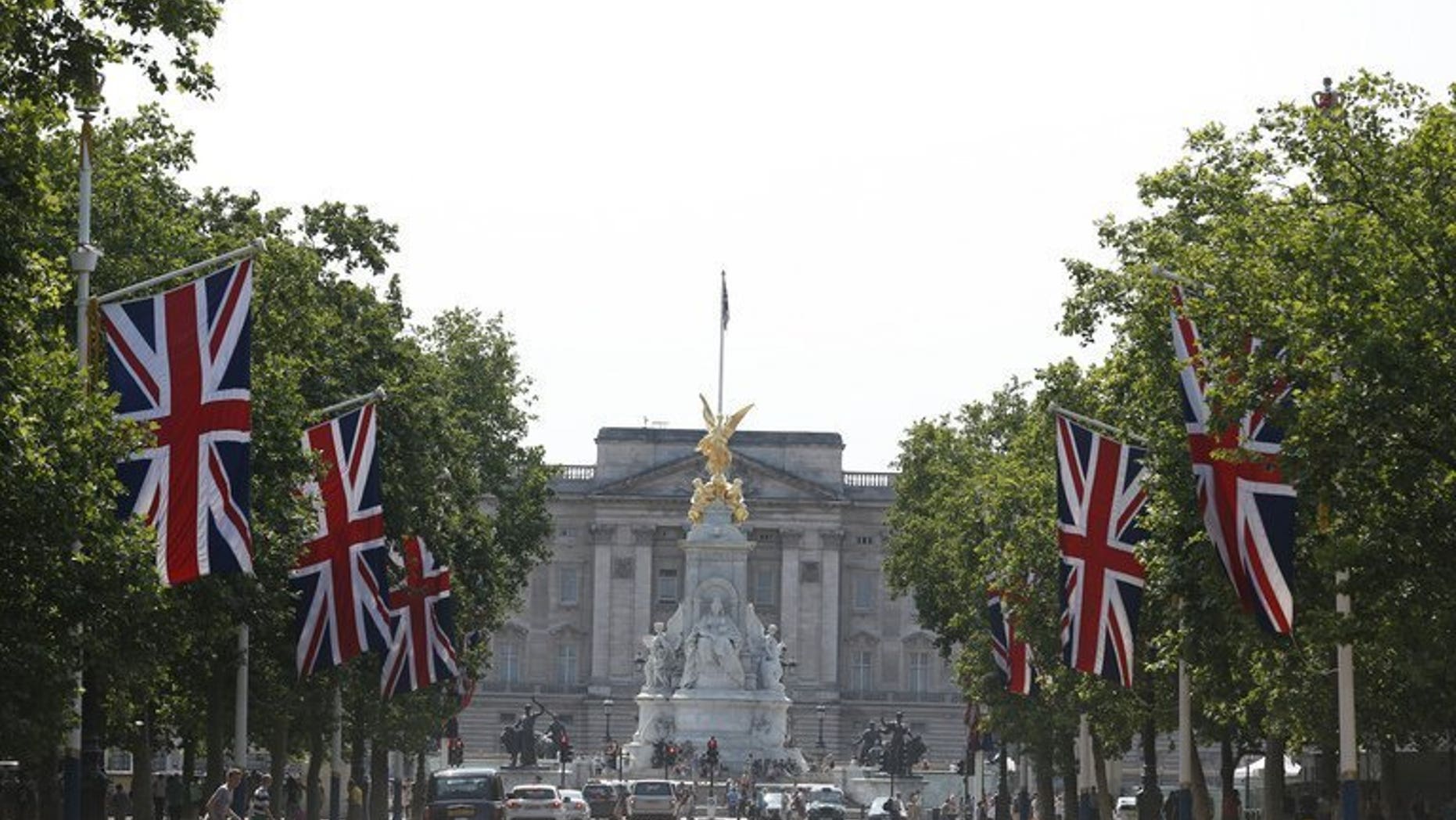 Britain's Union flags fly on the Mall leading to Buckingham Palace (background) in central London, on July 22, 2013. Prince William's wife Kate on Monday gave birth to a baby boy who will one day be heir to the British throne, Kensington Palace said in a statement.