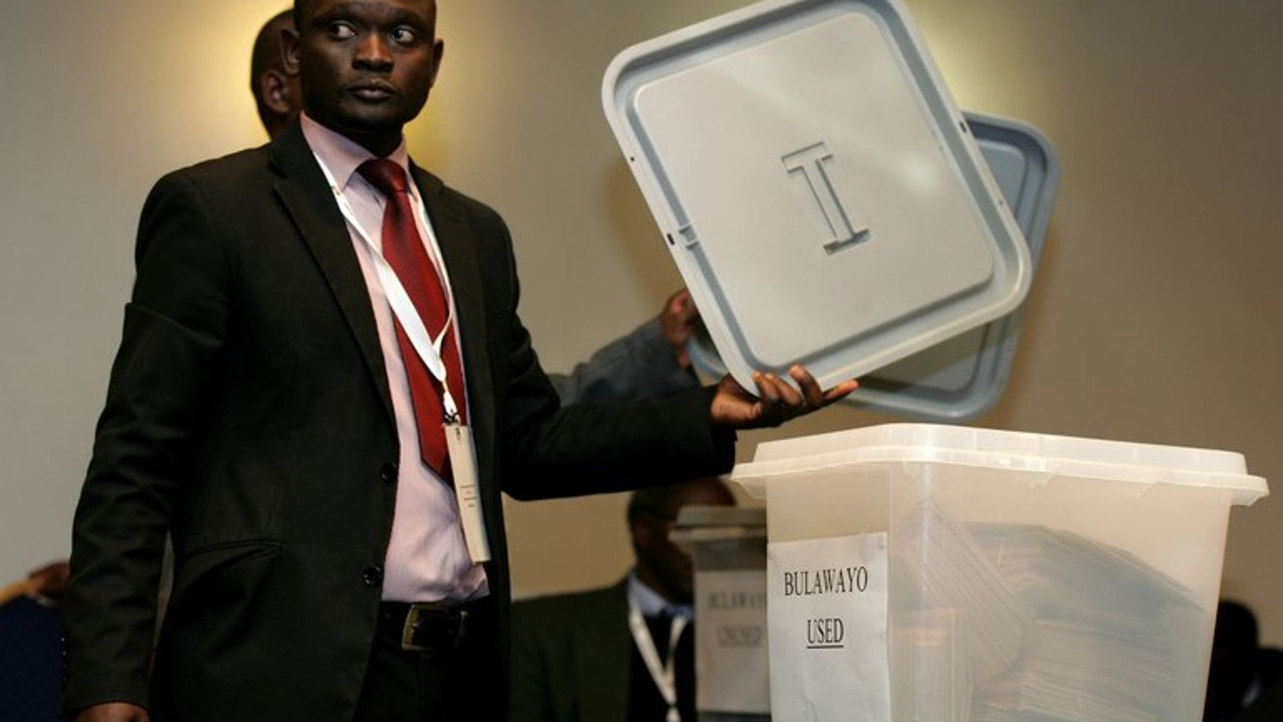 An official from the Zimbabwe Electoral Commission (ZEC) shows a lid before sealing a ballot box in harare on July 19, 2013. Zimbabwe election authorities insisted Tuesday that they would be ready to hold general elections in a week's time, despite fears of vote rigging and a lack of funding.