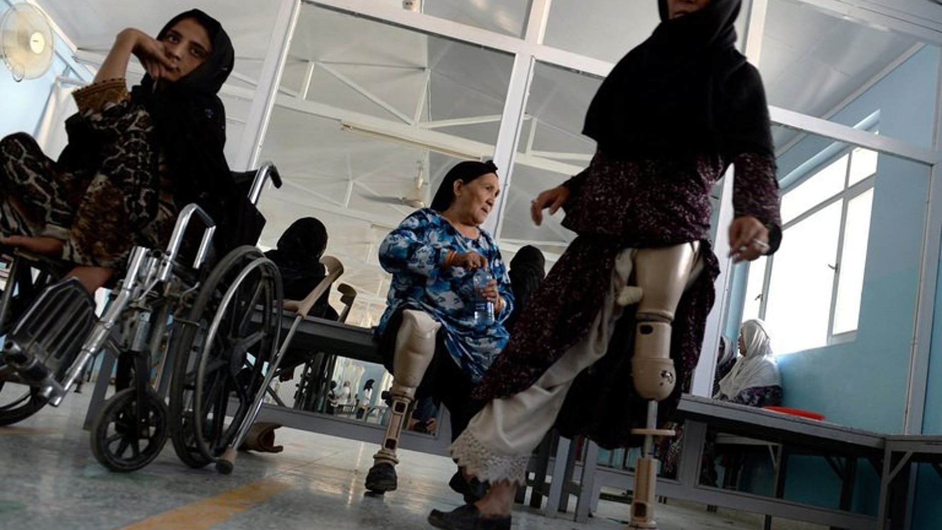 An Afghan amputee practices walking with her prosthetic leg at one of the International Committee of the Red Cross (ICRC) hospitals for war victims and the disabled in Kabul June 5, 2013. The Red Cross said Tuesday it will shut down three of its 17 offices in Afghanistan, two months after an unprecedented militant attack on the organisation.