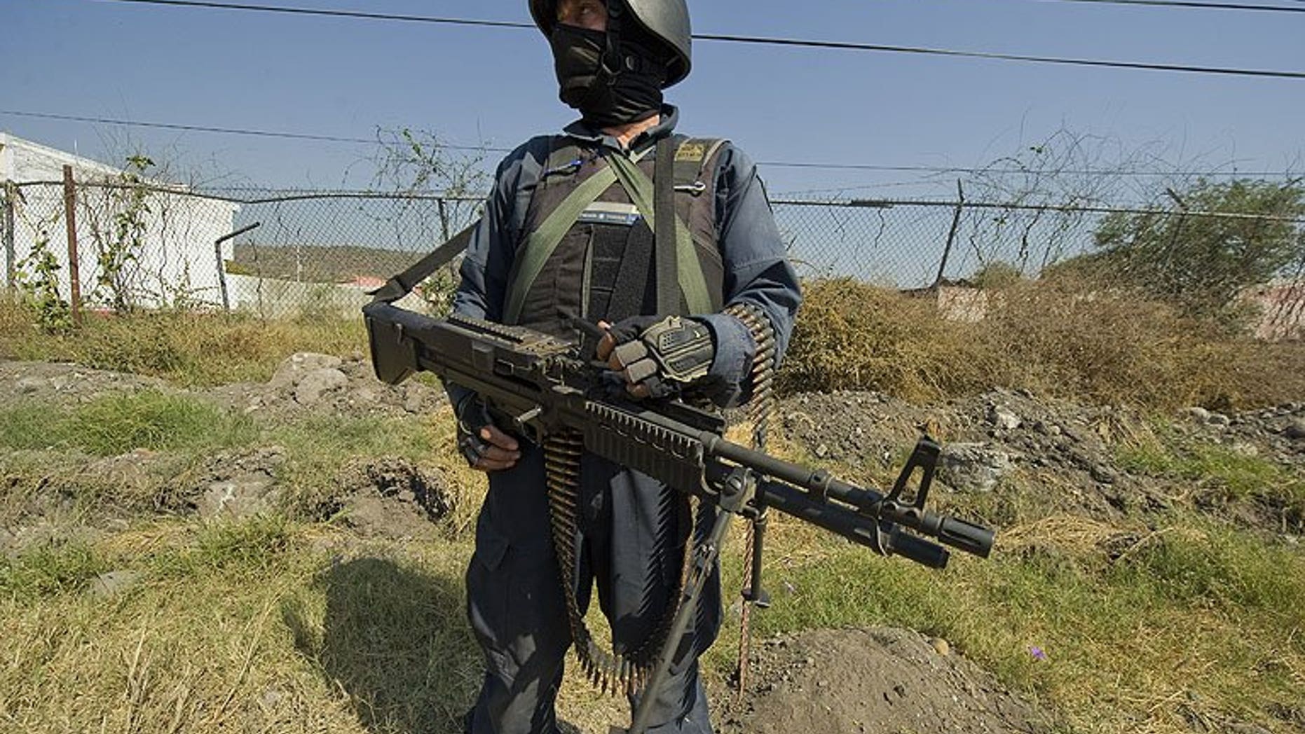 A Mexican policeman stands guard in Apatzingan, Michoacan State, on December 12, 2010. Heavily-armed men have assaulted Mexican federal police units in a carefully planned attack in which 22 people were killed in six towns, according to the government.