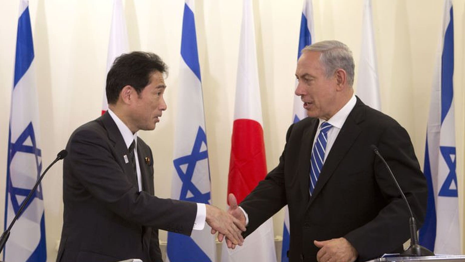 Japanese Foreign Minister Fumio Kishida (left) shakes hands with Israeli Prime Minister Benjamin Netanyahu during a joint press conference in Jerusalem, on July 24, 2013. Netanyahu has urged greater pressure on Iran over its nuclear programme as he met Kishida.