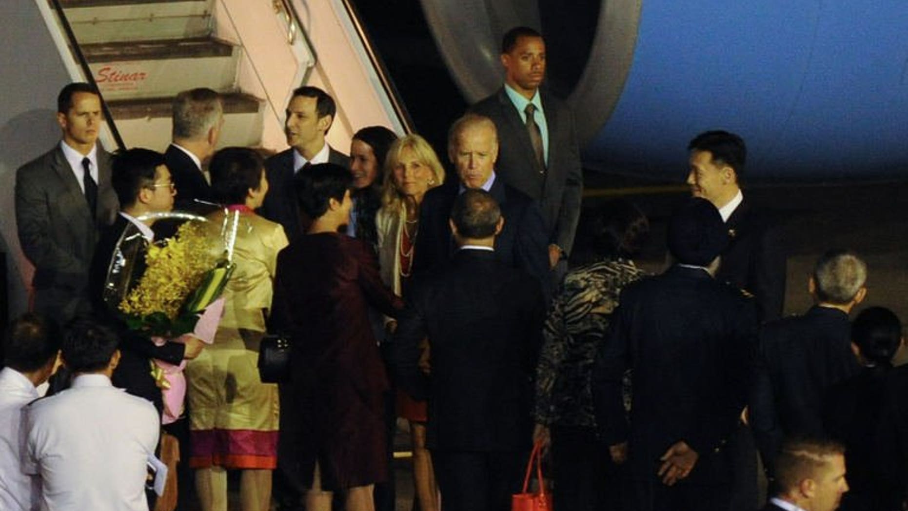US Vice President Joe Biden (centre R) with his wife Jill Biden (centre L) greeted by officials upon arrival at the Paya Lebar military airport in Singapore on July 25, 2013. Biden arrived in Singapore on Thursday for a visit in which he is expected discuss trade ties and ways to calm regional maritime tensions.