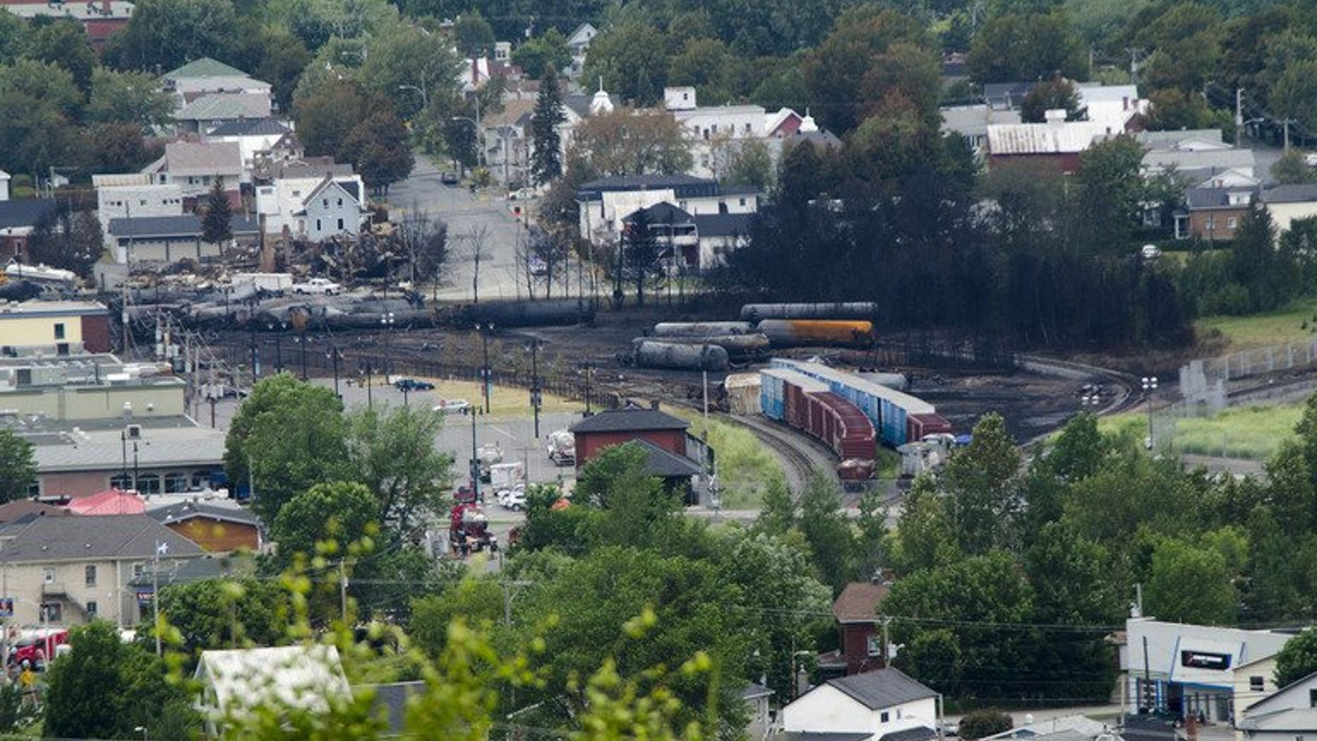 Scorched oil tankers remain on July 10, 2013 at the train derailment site in Lac-Megantic, Quebec. Police on Thursday raided the Canadian regional office of the Montreal, Maine & Atlantic (MMA) railway, looking for evidence in a criminal investigation of a train derailment that killed 47 people.