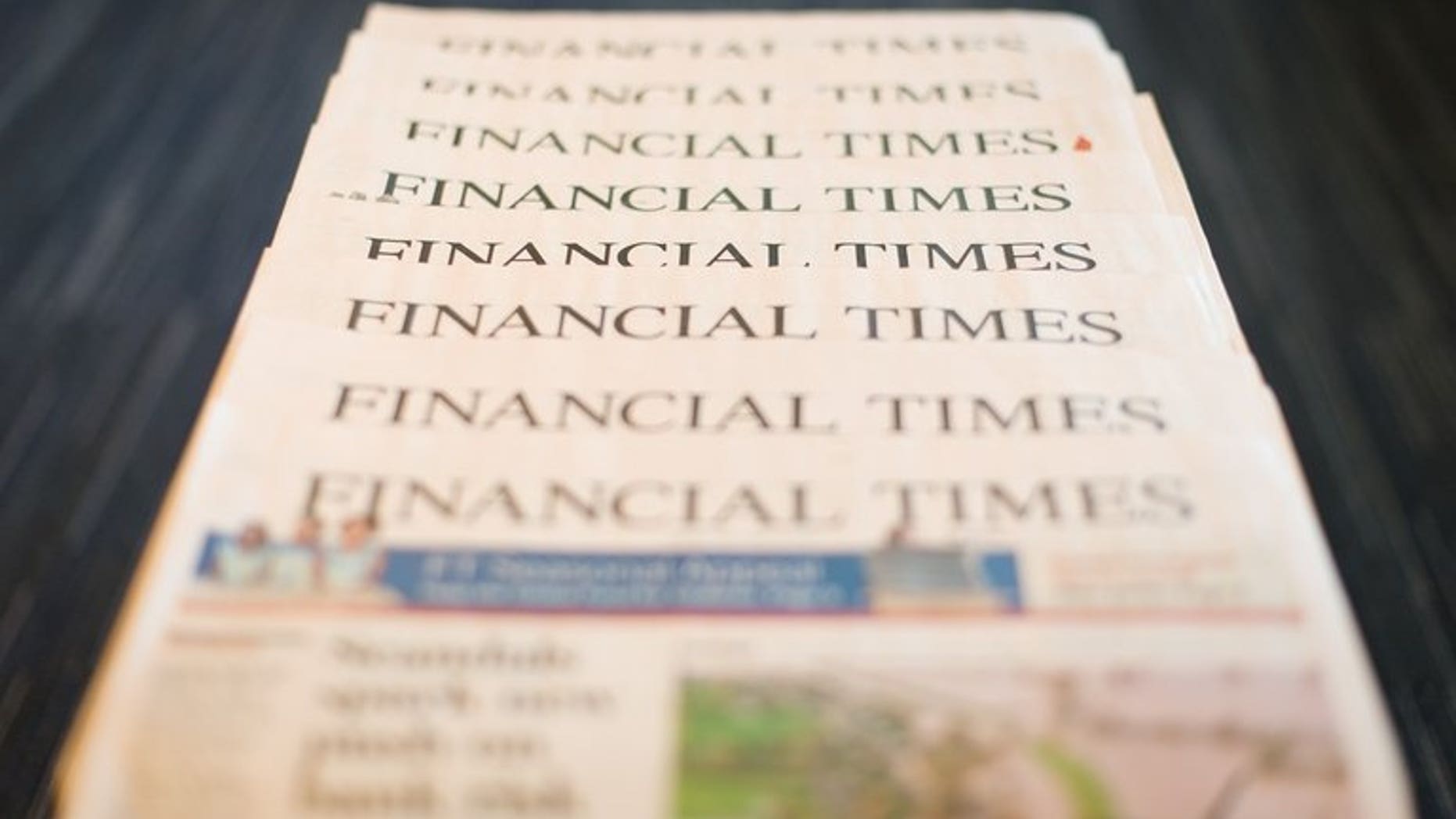 Copies of Pearson's Financial Times newspaper for December 11 last year. British publisher Pearson fell into a first-half net loss on the back of restructuring costs, the group said on Friday, but better-than-expected revenues sent its share price surging.