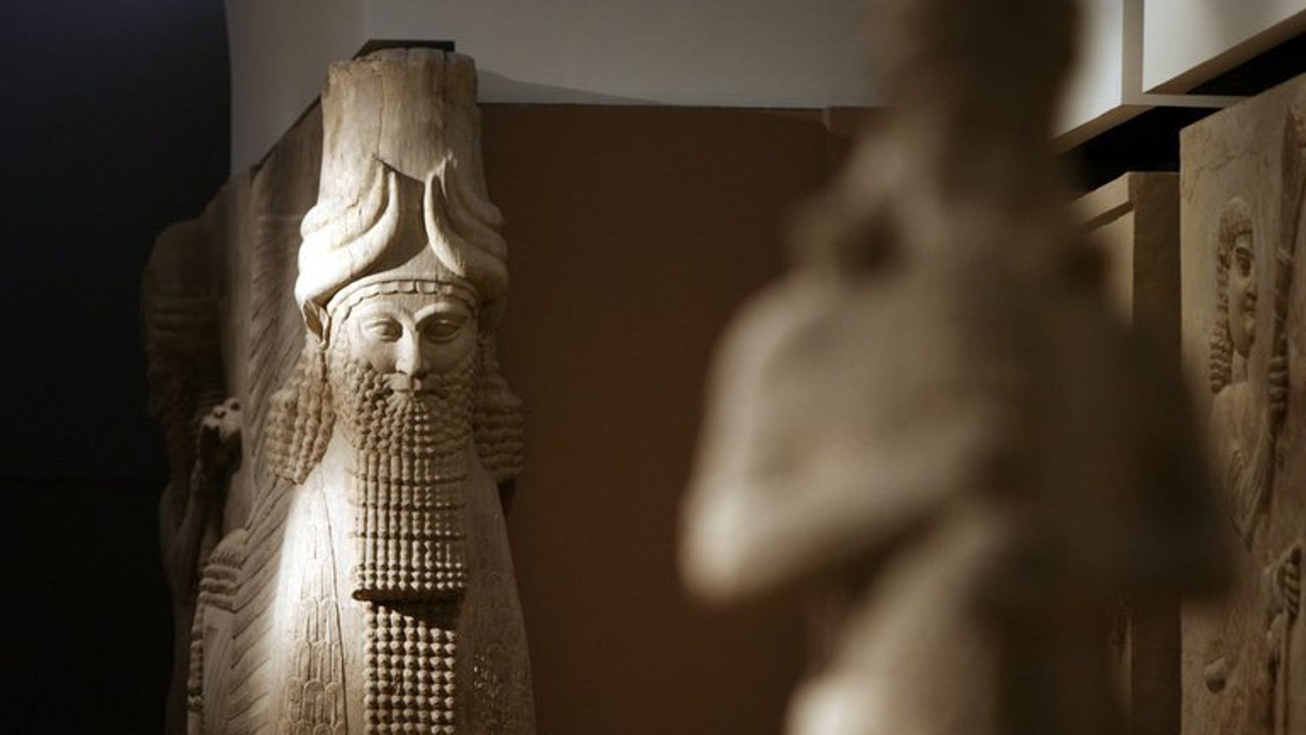 A statue is lit by natural light inside the Assyrian Hall of the Iraqi National Museum on September 21, 2010. Some 15,000 artefacts were stolen from the national museum in Baghdad by looters in the chaos that followed the 2003 US-led invasion of Iraq. Baghdad reached an initial deal with the US on the return of more than 10,000 artefacts stolen from Iraq after the 2003 US-led invasion.
