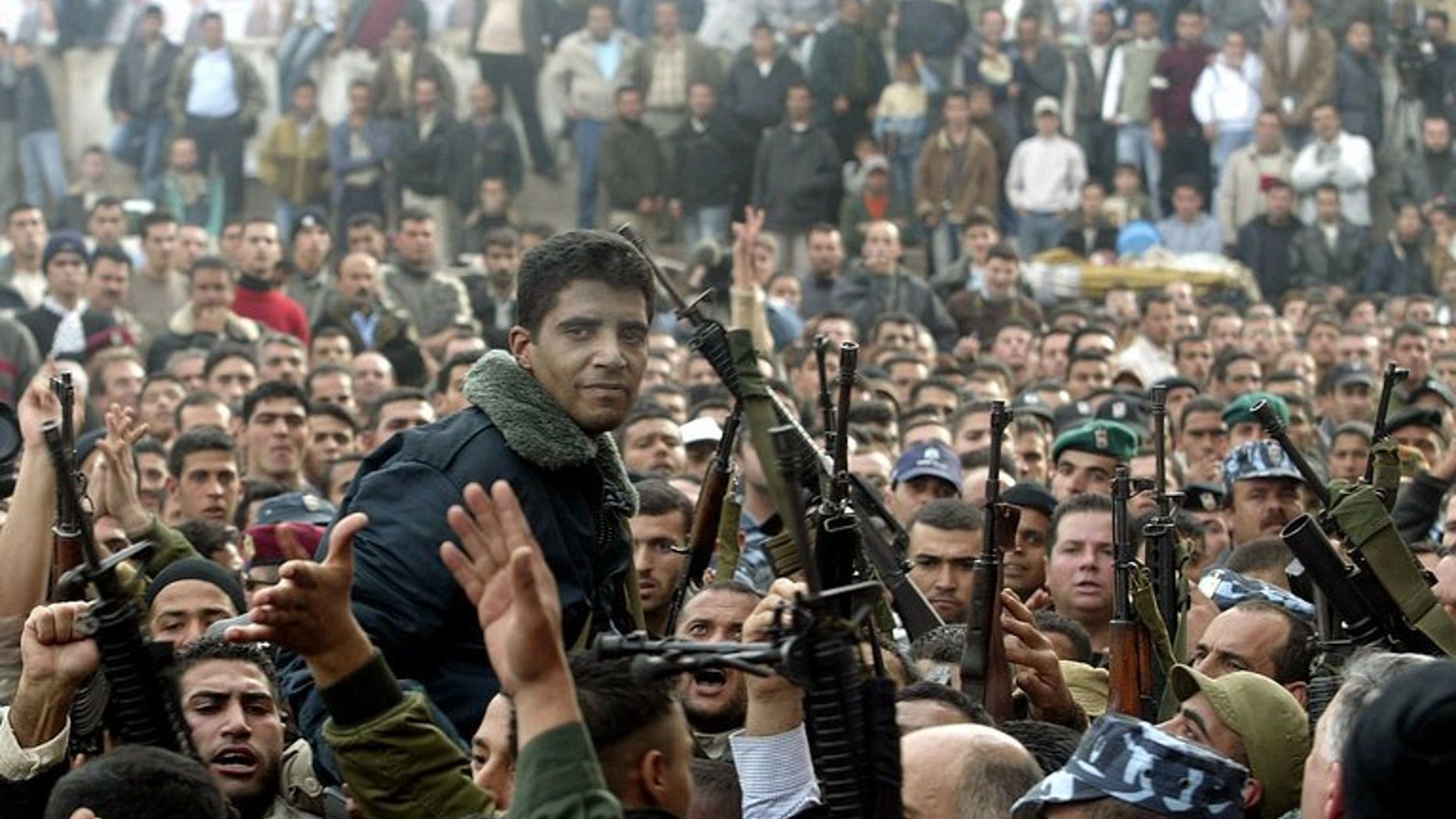 Palestinian militant leader Zakaria Zubeidi (center) and supporters take part in a rally in the West Bank town of Jenin on December 30, 2004. Zubeidi's brother, Daoud Zubeidi, was arrested by Israeli security forces on Friday, Palestinian security forces said.