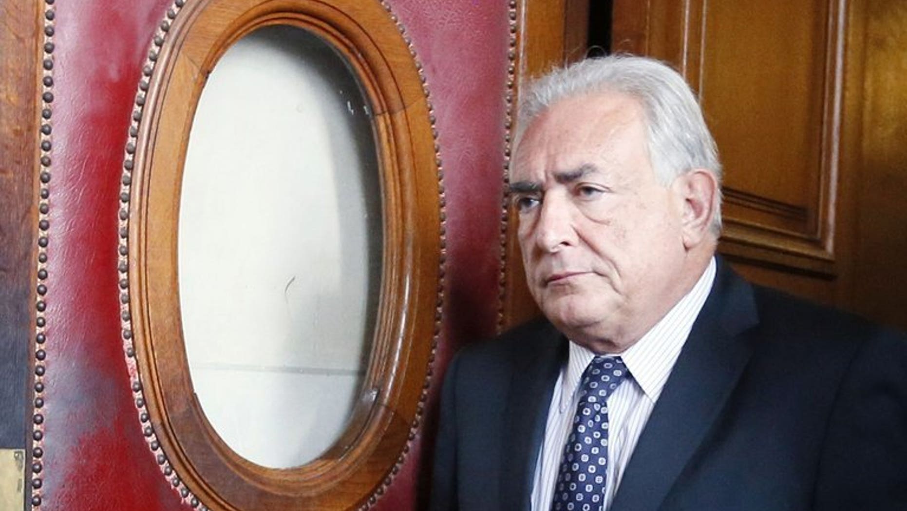 A picture taken on February 26, 2013 in Paris shows French former IMF chief Dominique Strauss-Kahn leaving a courthouse. Strauss-Kahn will face trial on pimping charges along with 12 others in connection with an alleged prostitution ring at a Lille hotel, the local prosecutors' office said.