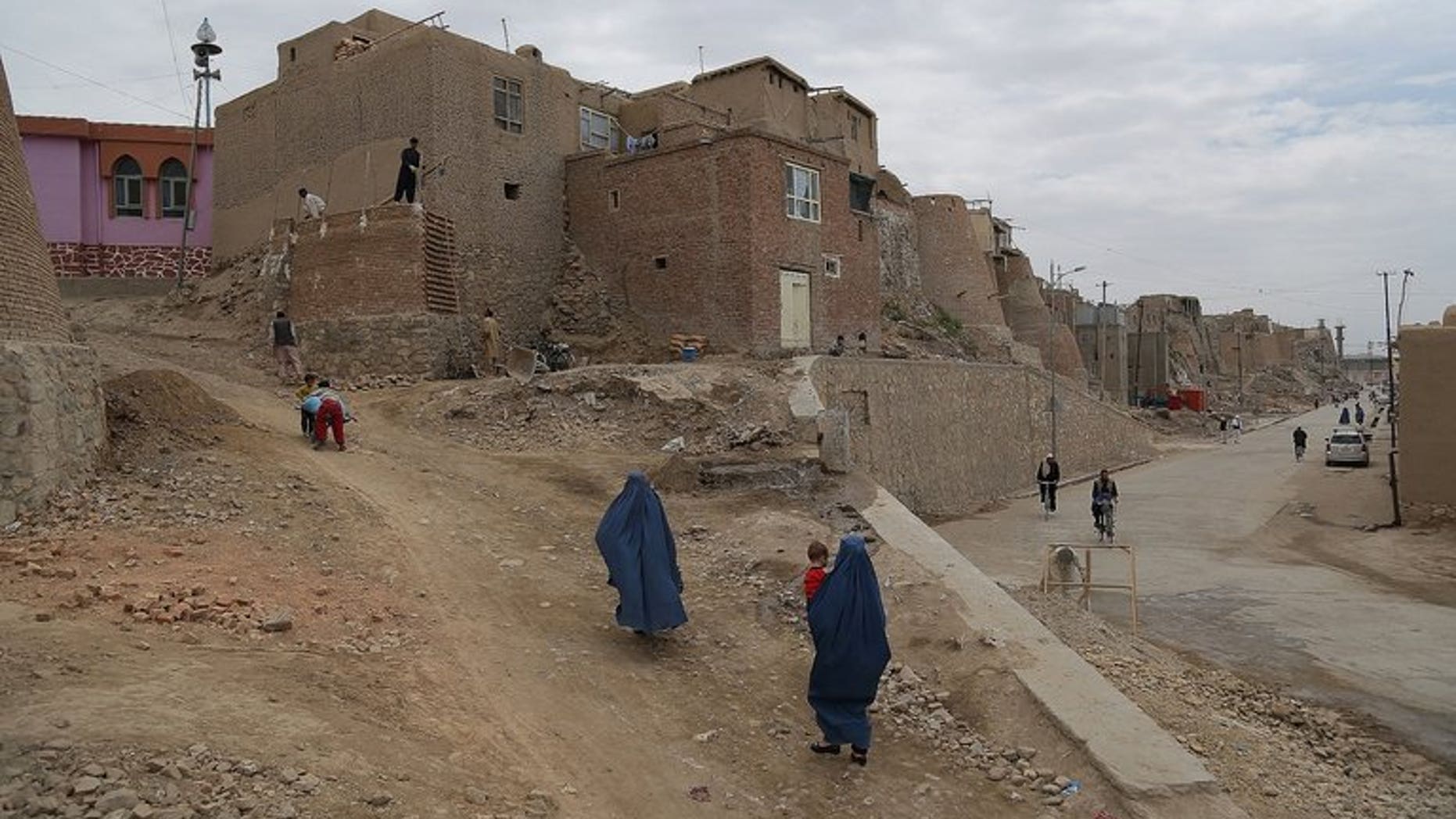 Afghan residents walk in a section of the old city in Ghazni province on June 30, 2013. A suicide bomber on a motorcycle struck a busy marketplace in the area, killing at least seven people including an anti-Taliban militia leader, officials said.
