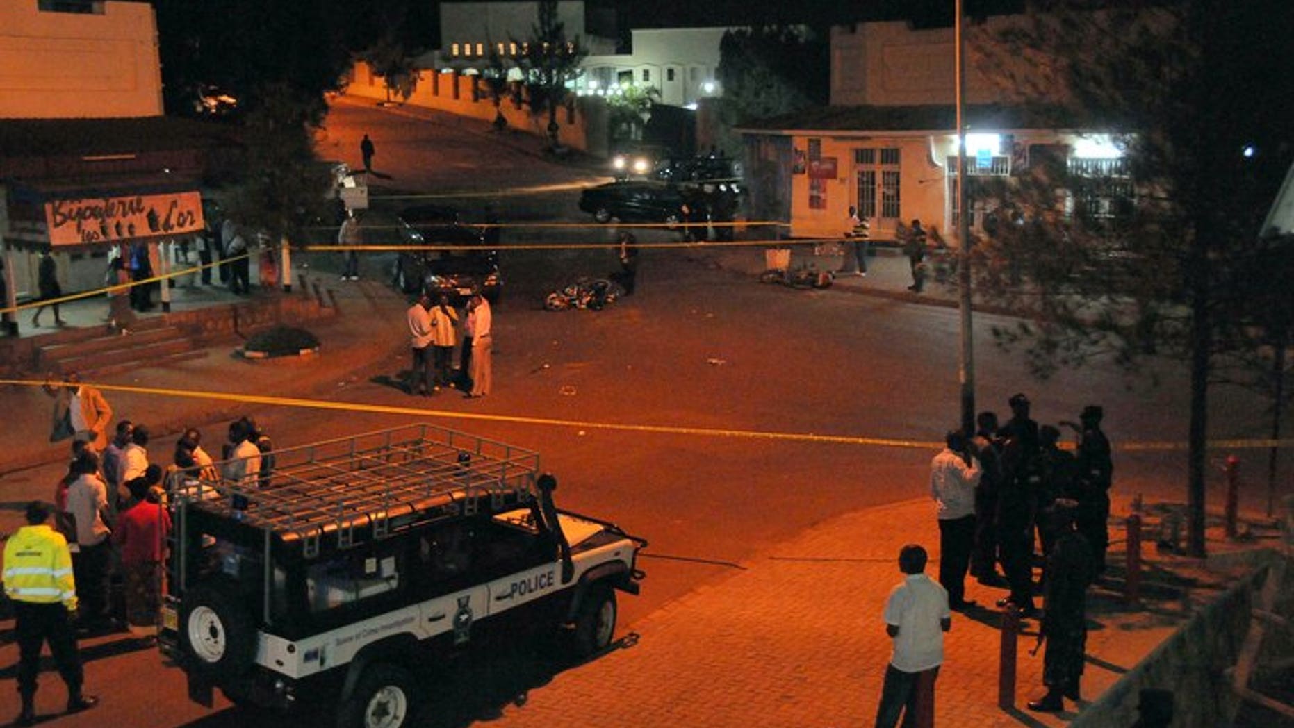 Rwanda National Police forensic officers examine the site of a grenade blast in the city-center of Kigali on March 30, 2012. A grenade attack in the Rwandan capital Kigali killed three people, police said Saturday, after a third victim succumbed to his injuries.