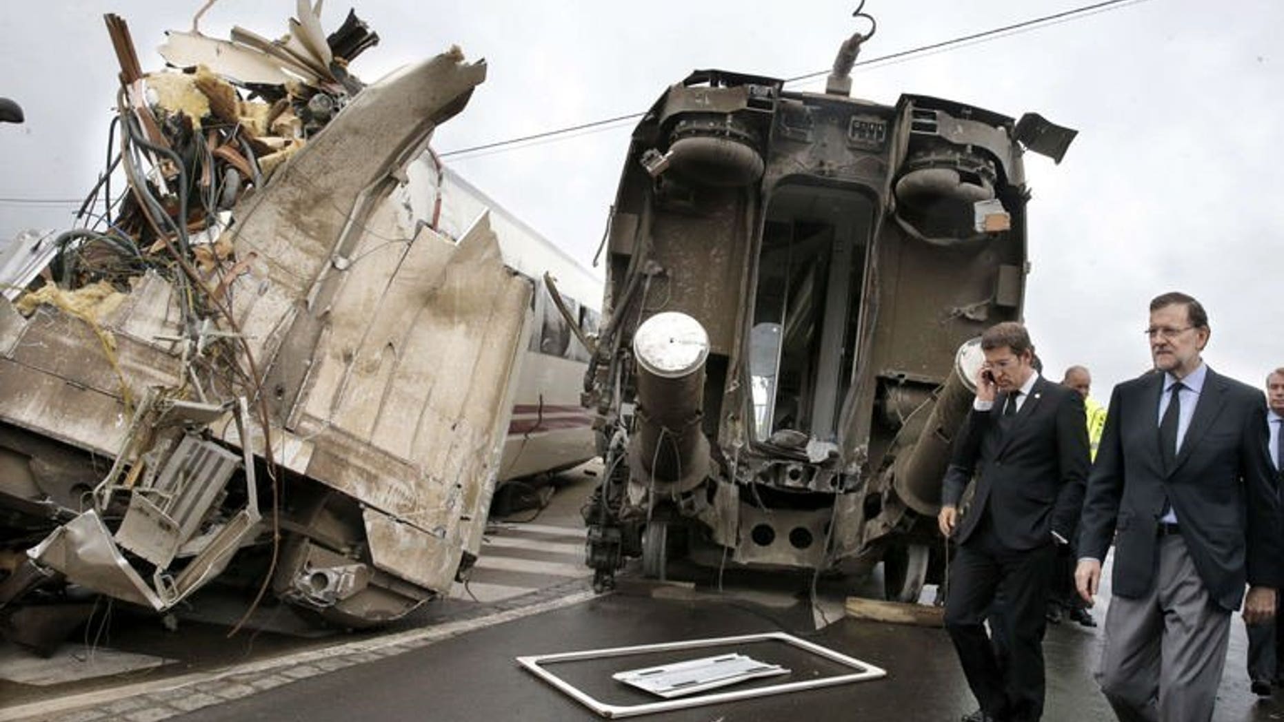 Mariano Rajoy (right) and Galicia's regional president Alberto Nunez Feijoo visit the train crash site on Friday. The driver of a speeding train that hurtled off the rails killing 78 people in Spain was detained for "reckless homicide", Interior Minister Jorge Fernandez Diaz said Saturday.