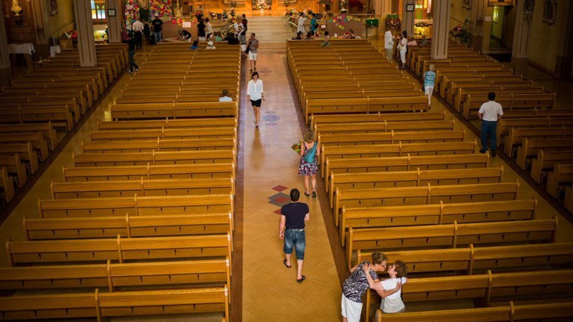Residents of Lac-Megantic gather and pray at the Presbyteres-Eglises Catholique July 13, 2013 in Lac-Megantic, Quebec, Canada. Several thousand people attended a memorial service Saturday for the 47 victims of Canada's rail disaster, caused when a runaway train laden with oil went off the tracks and exploded.