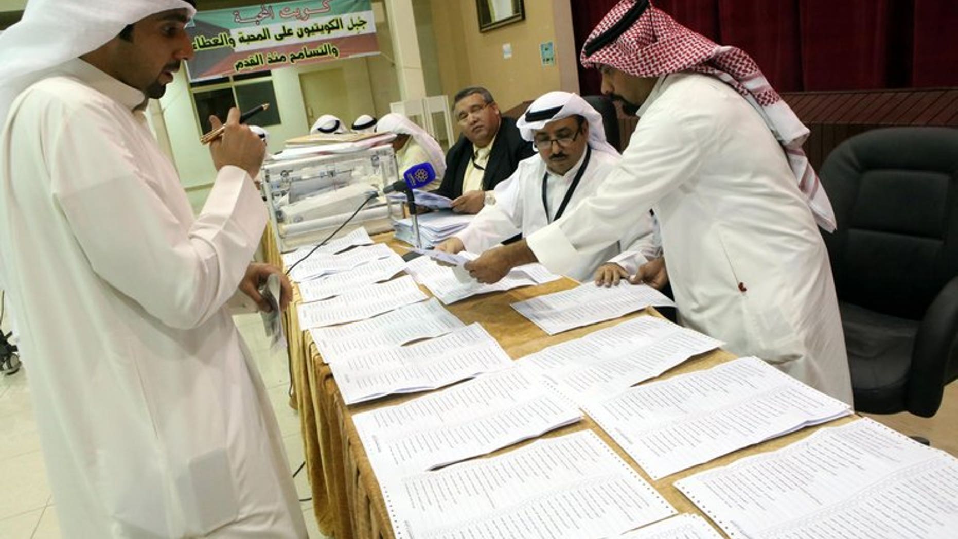Judges and their aides count the ballots at a polling station in Kuwait City on July 27, 2013. Kuwait's Shiite minority lost more than half of their seats and liberals made slight gains in the Gulf state's second polls in eight months.