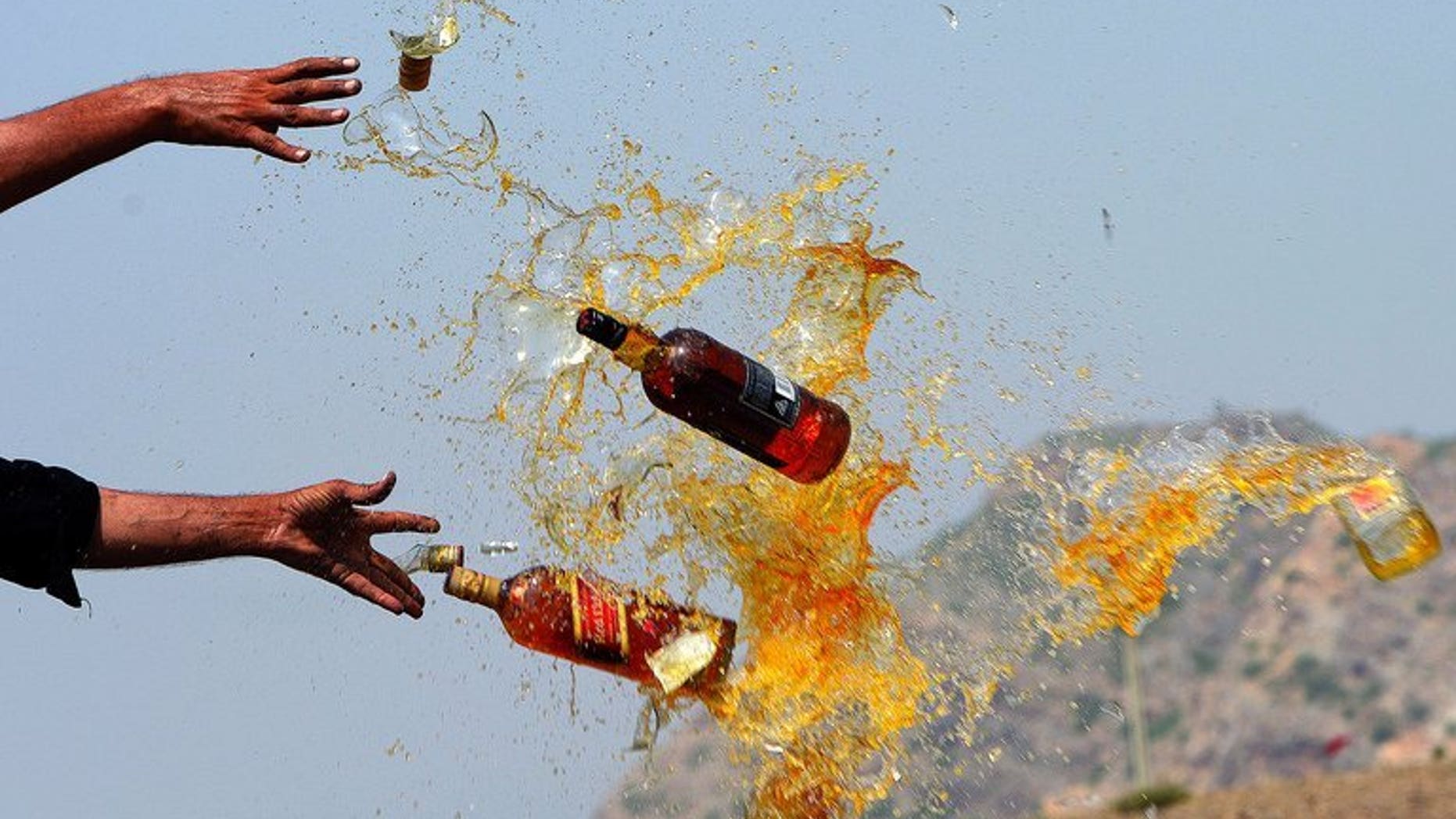 This file photo shows Pakistani officials destroying contraband alcohol, in the Shahkas area of the Jamrud Khyber Agency, on June 26, 2013. At least 18 people died and around two dozen others suffered serious health issues after partygoers at two separate events consumed toxic drinks in central Pakistan, officials said on Sunday.