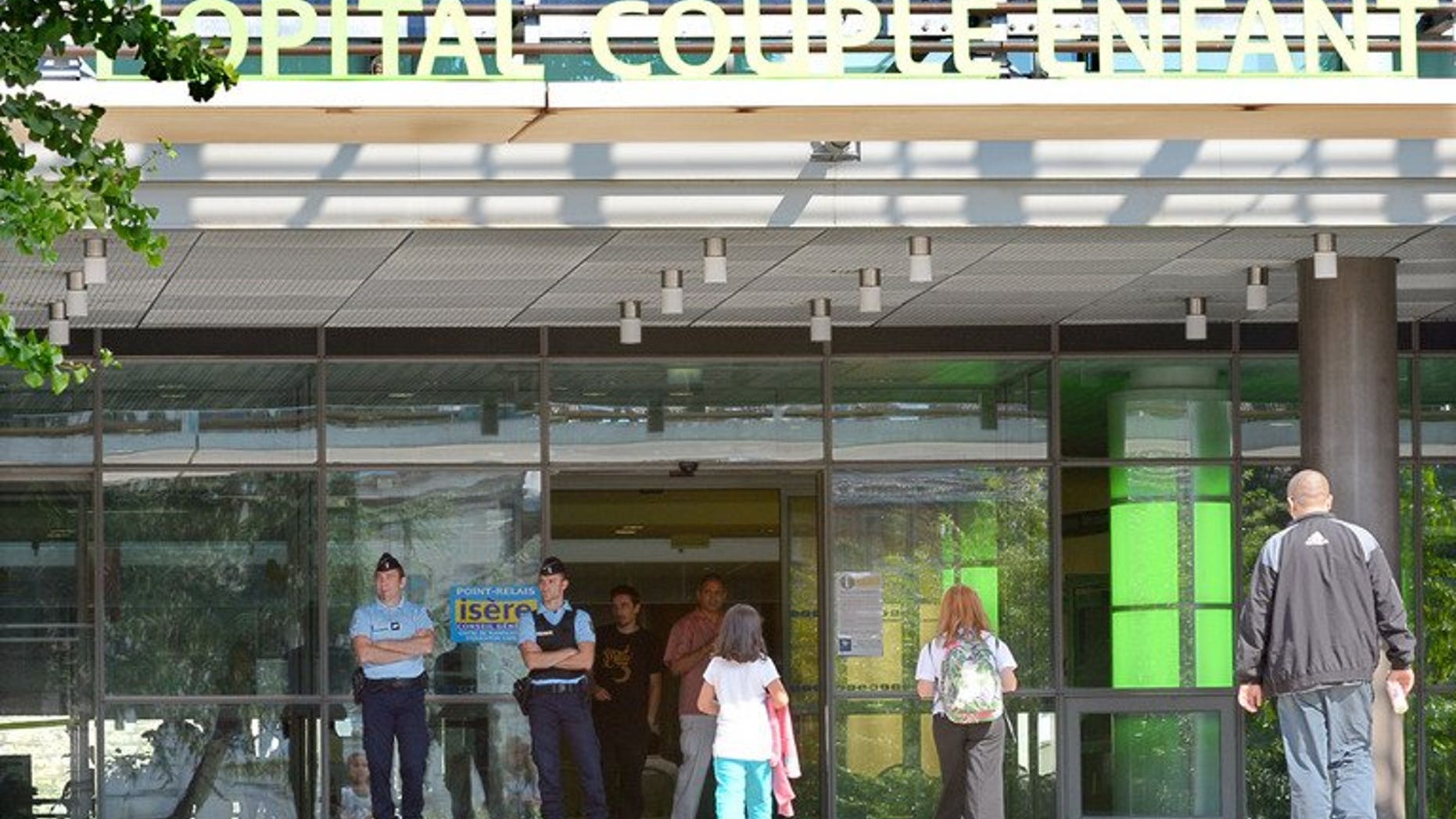 French gendarmes stand guard on September 10, 2012 at the entrance of the Grenoble's CHU Hospital French Alps, where the elder of two child survivors of the French Alps shooting remained under sedation. The two young sisters who were orphaned can be brought up by relatives, a British judge has ruled.