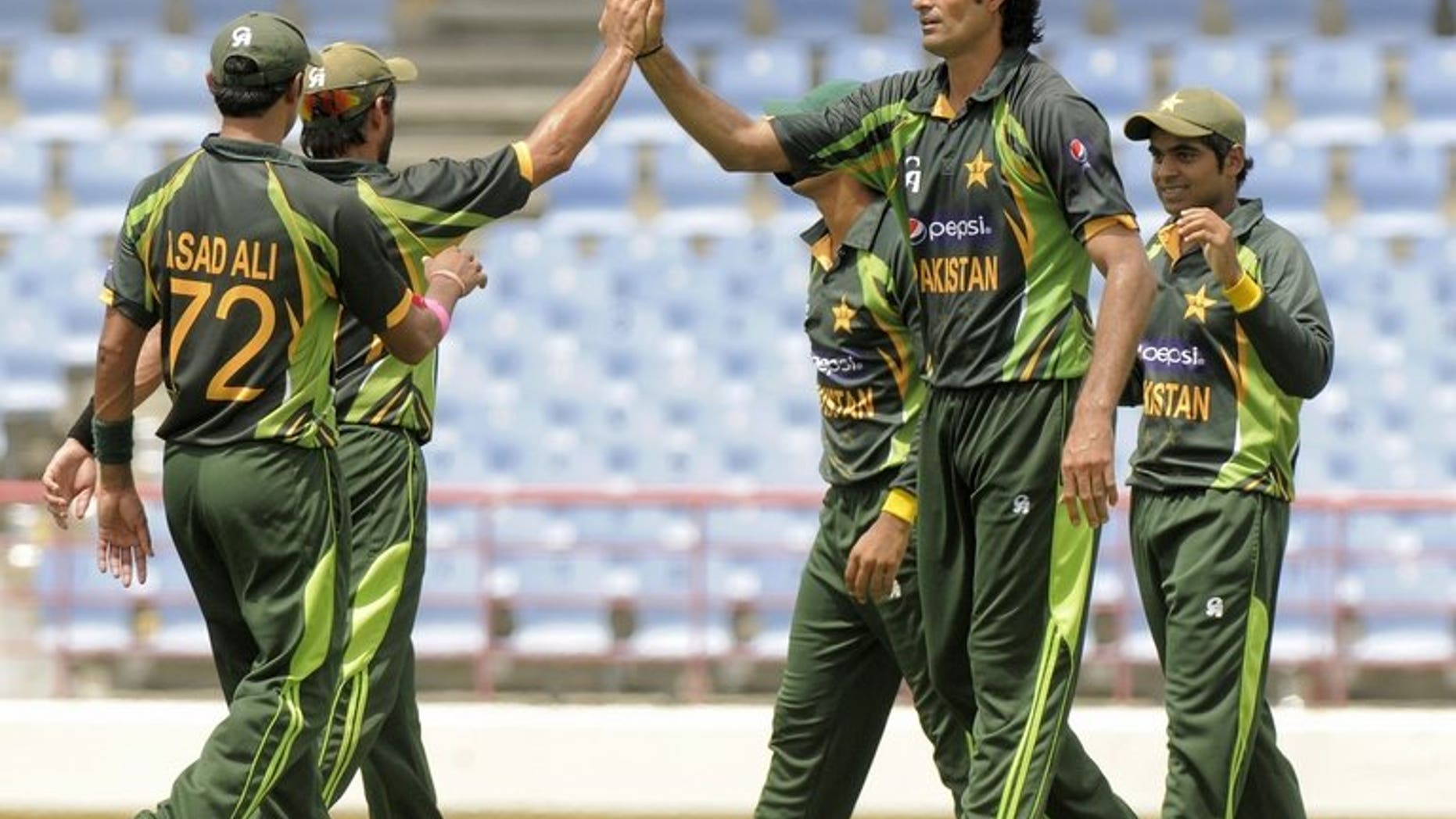 Pakistan bowler Mohammad Irfan (C) celebrates the dismissal of West Indies batsman Johnson Charles, caught Haris Sohail (R) during the 5th and final ODI West Indies v Pakistan on July 24, 2013. Pakistan defeated the West Indies by 11 runs to sweep the Twenty20 series 2-0 at Arnos Vale.