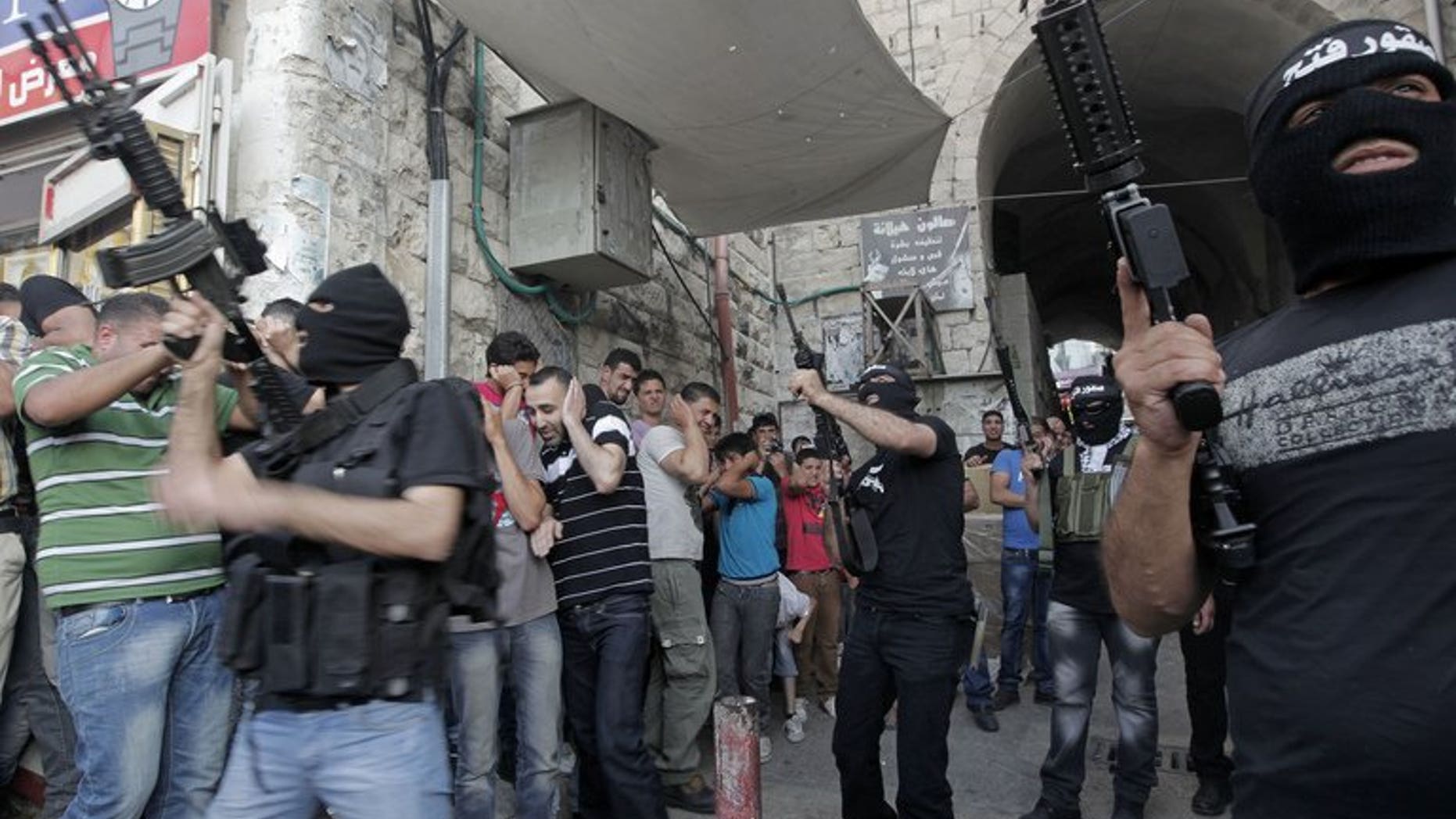 Militants of Al-Aqsa Martyrs' Brigade fire celebratory shots during a ceremony for group member Jamal Nablusi in the West Bank city of Nablus on June 2, 2013 following his release from Israeli prison after serving eight years. As negotiators headed to Washington for the resumption of peace talks on Monday, most Israeli newspapers hit out at the decision to free 104 prisoners in return.