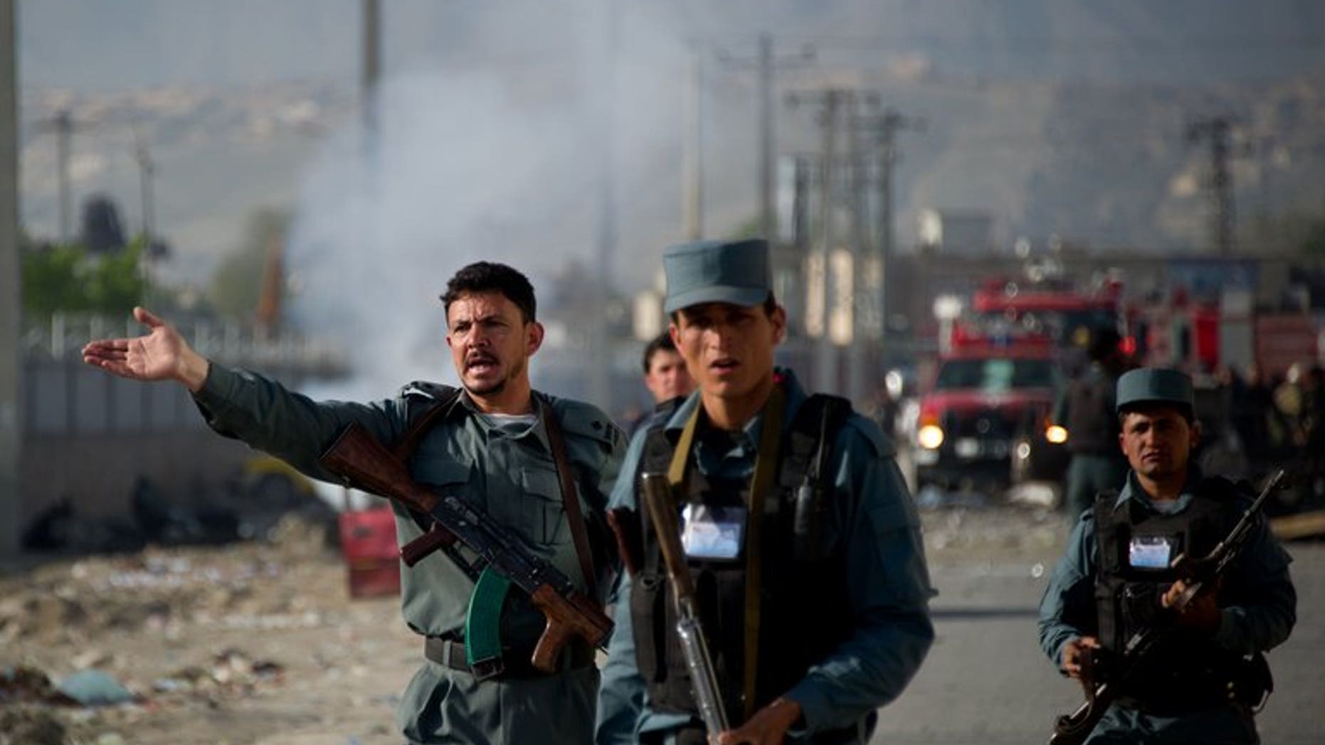 Afghan police personnel gesture as they evacuate onlookers from the site of a suicide bomb attack in Kabul on May 2, 2012. A roadside bomb blamed on the Taliban tore through a police vehicle in southern Afghanistan at the weekend, killing nine people and wounding 15, officials said on Monday.