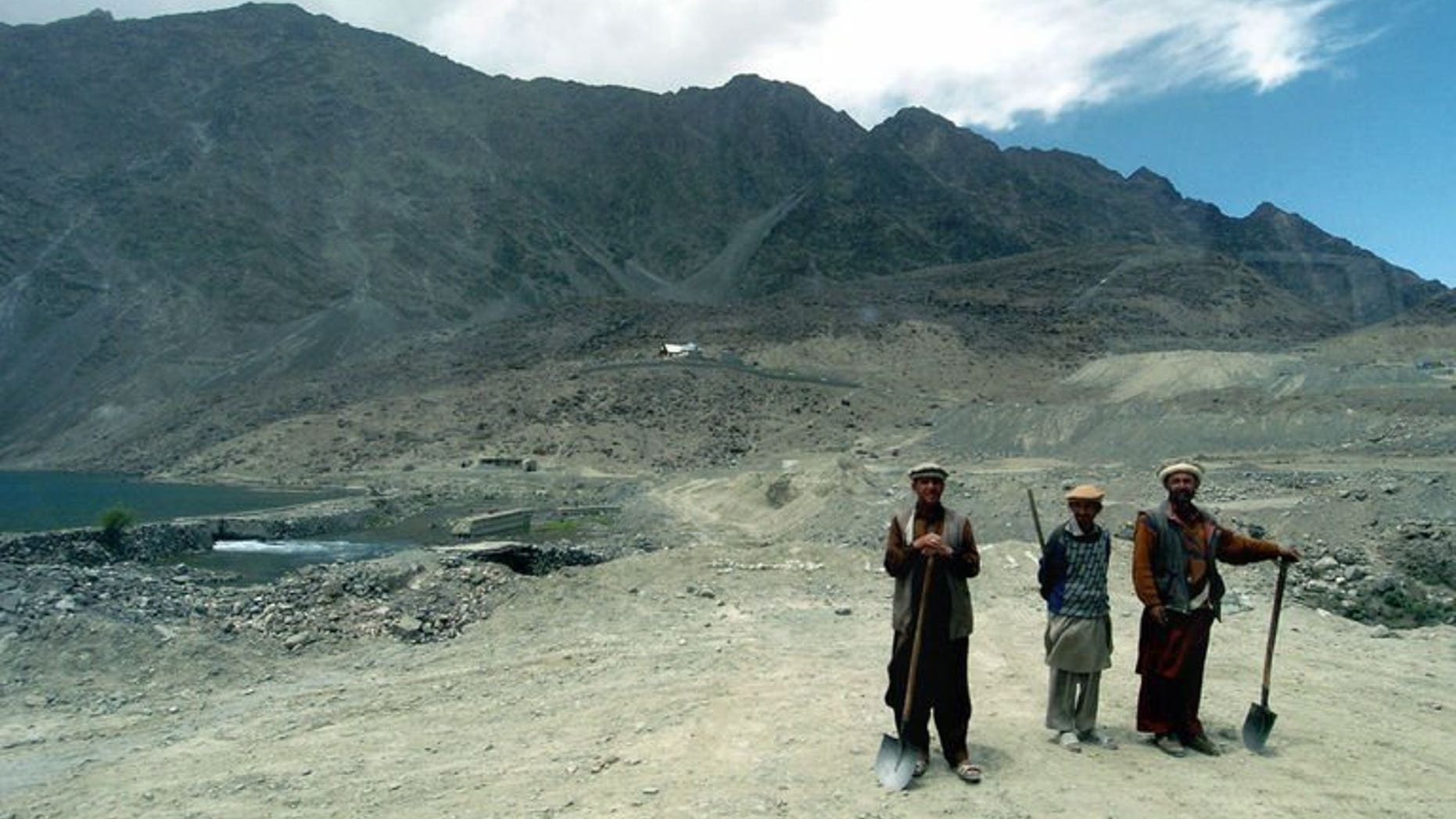 Picture taken July 13, 2004 shows three labourers with the mountains of the Himalayan Karakoram range in the background, on the outskirts of Skardu, some 300 kms north of Islamabad. Two New Zealand climbers have gone missing after an avalanche on the world's second-highest mountain, K2, in the Karakorams, a Pakistani official said Monday.
