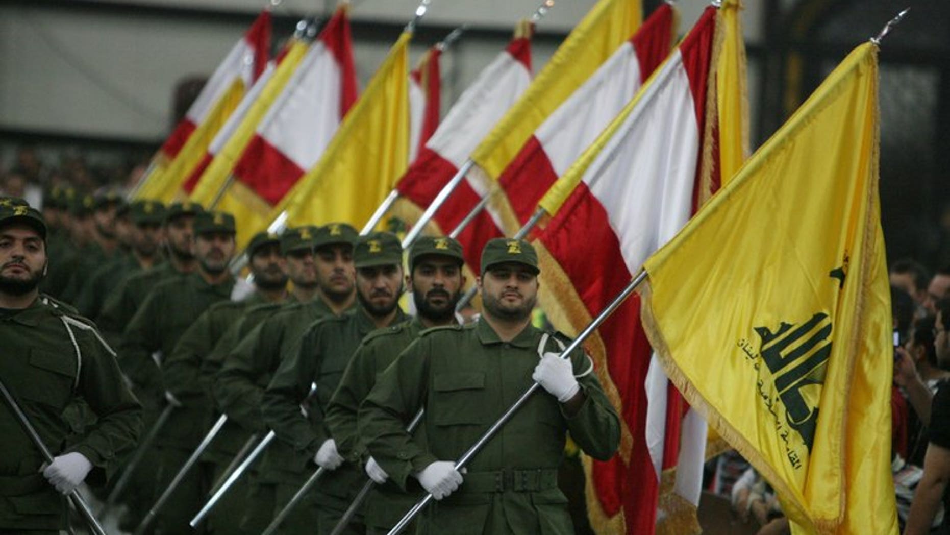 Hezbollah fighters hold up Lebanese flags and the yellow flag of the militant Shiite Muslim group in Beirut on November 11, 2009. Nigerian prosecutors on Monday widened charges against three Lebanese nationals accused of links to Hezbollah as their trial began with access to the courtroom restricted and the identities of witnesses concealed.