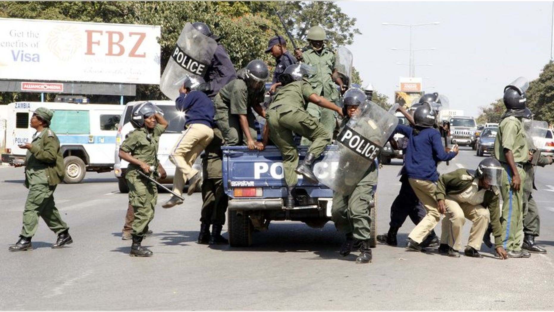 Zambian police officers arrive at the University of Zambia on May 17, 2013 in Lusaka. Zambian police on Monday arrested and charged a journalist with having porn on his computer in another apparent crackdown on a publication critical of the government, his lawyer said.