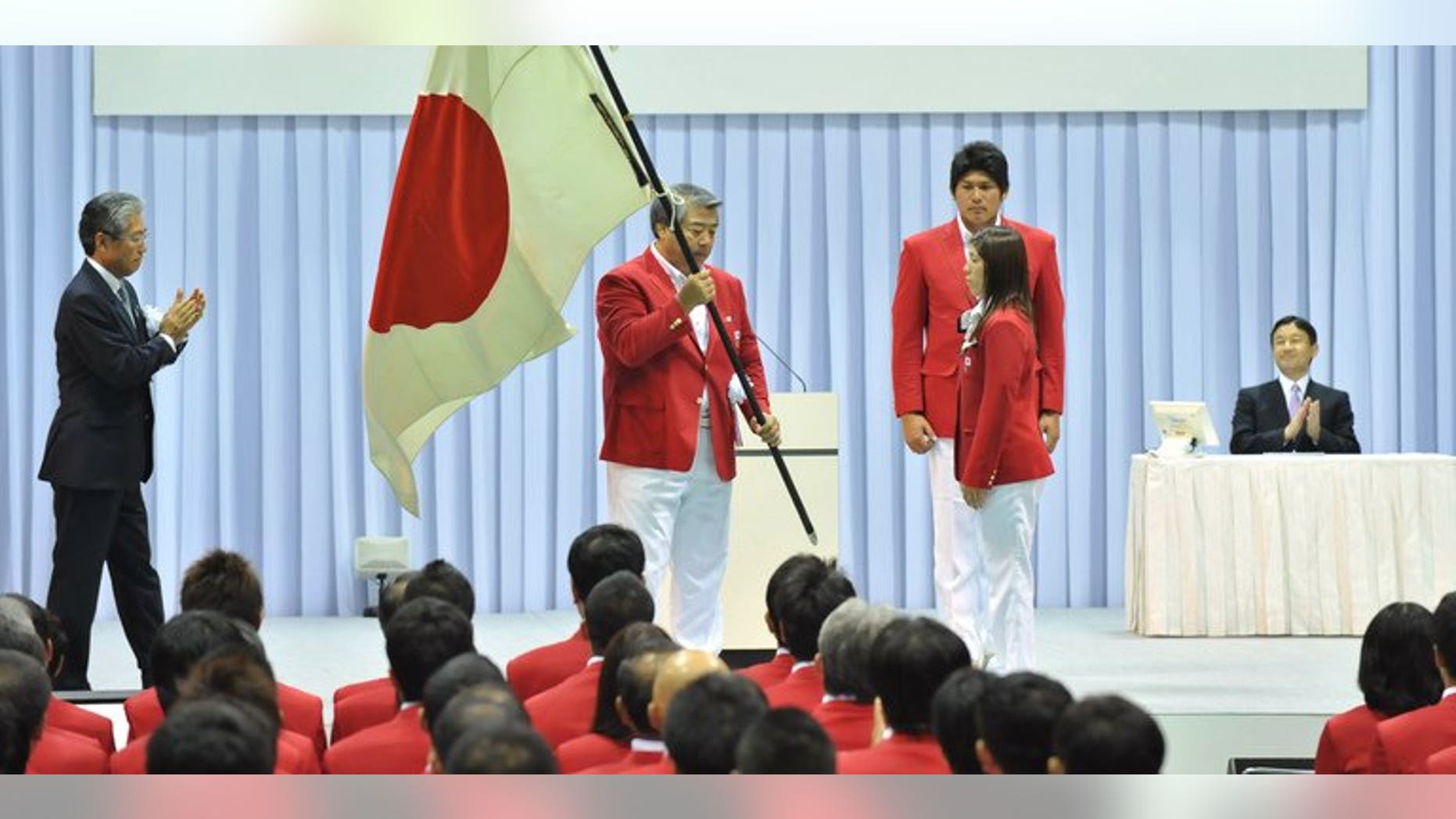 The head of the All Japan Judo Federation Haruki Uemura (C) holds the national flag at a ceremony in Tokyo in 2012. Uemura is to announce his resignation according to reports, after the sport was sullied in its birthplace by a series of scandals including abusive coaching, sexual harassment and misuse of funds.