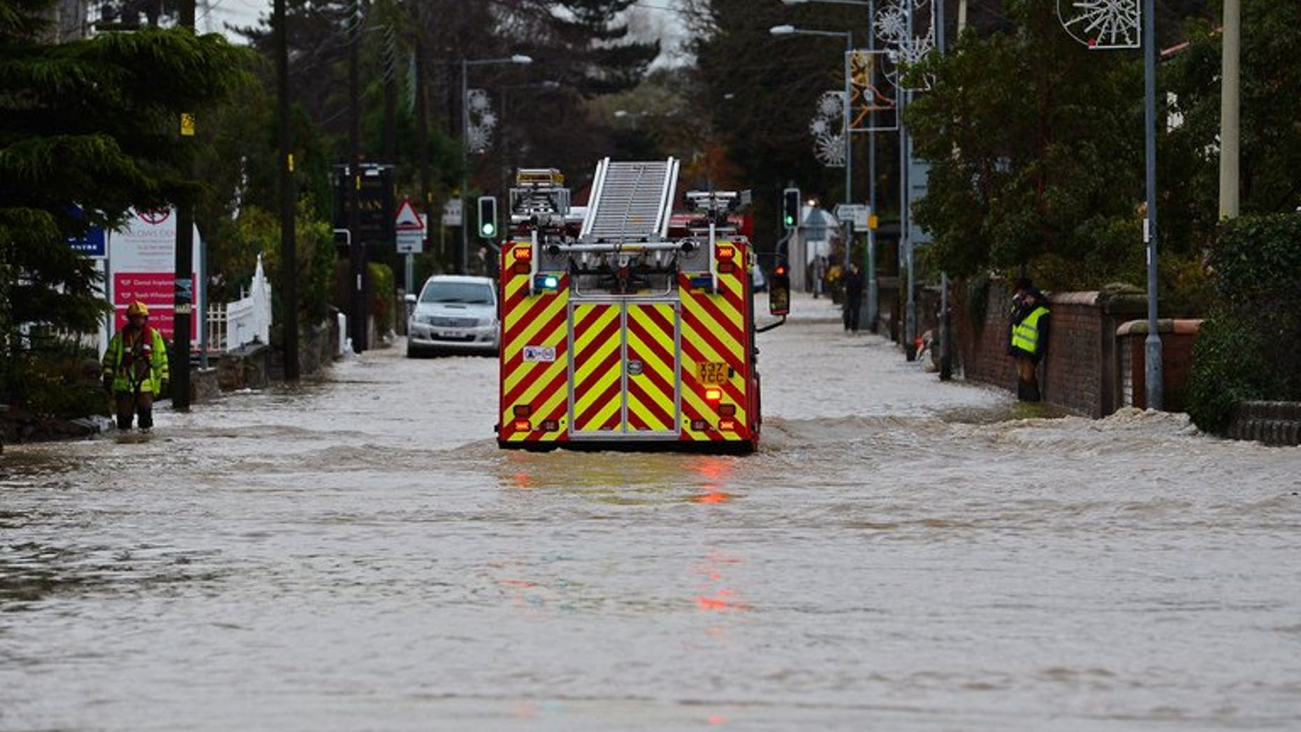 Fire crews pumped water out of properties in the West Yorkshire town of Todmorden after a "torrential" downpour caused flash floods. File picture for illustration only shows a fire engine moving along a flooded road.
