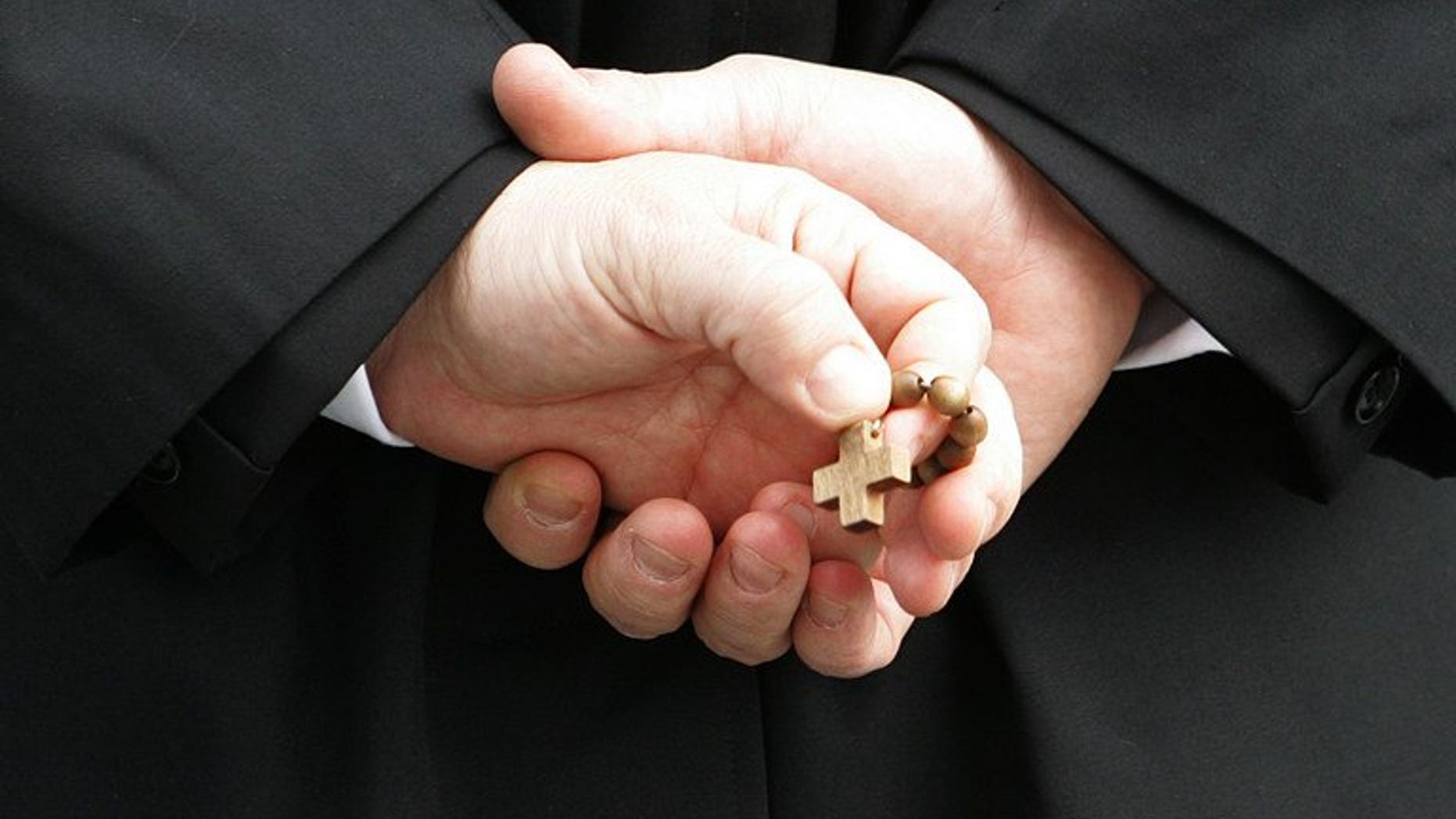 A priest in Rome holds a rosary on February 27, 2005. Scottish police are investigating claims of physical and sexual abuse at one of Scotland's best known Catholic boarding schools.