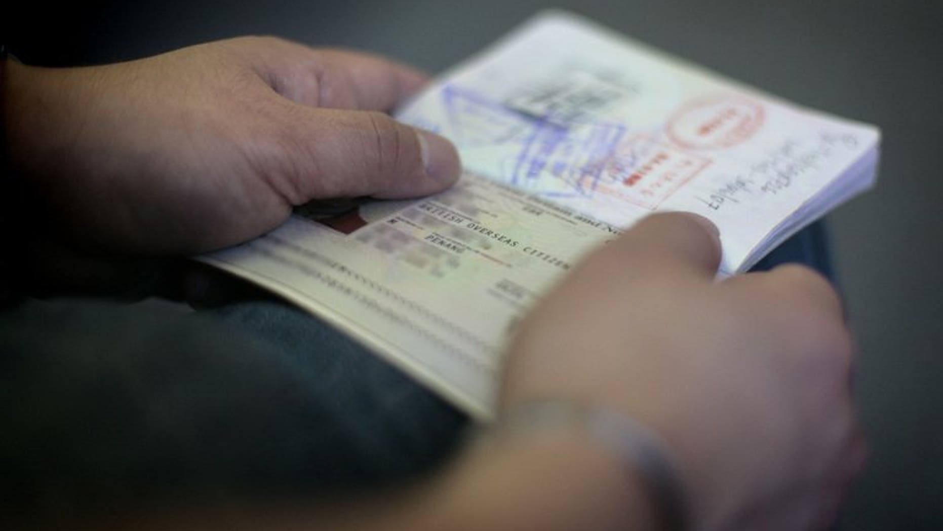 A former Malaysian citizen is pictured with a British Overseas Citizen (BOC) passport in east London on August 6, 2009. Almost 100 foreign suspected war criminals were found to be living in Britain last year after applying for citizenship or asylum, the Home Office said.