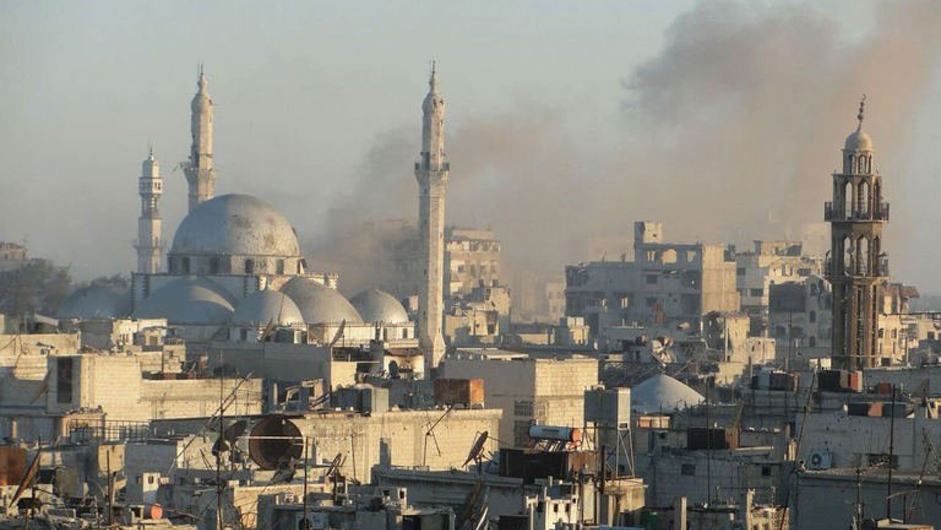 Image released by the Syrian opposition's Shaam News Network on July 27, 2013, claims to show smoke billowing from buildings near Khaled bin Walid mosque in the Khalidiyah neighbourhood of the central Syrian city of Homs. Seven children in the northern Syrian province of Aleppo and another four in Homs were among 17 civilians killed in air raids on Tuesday, a watchdog said.