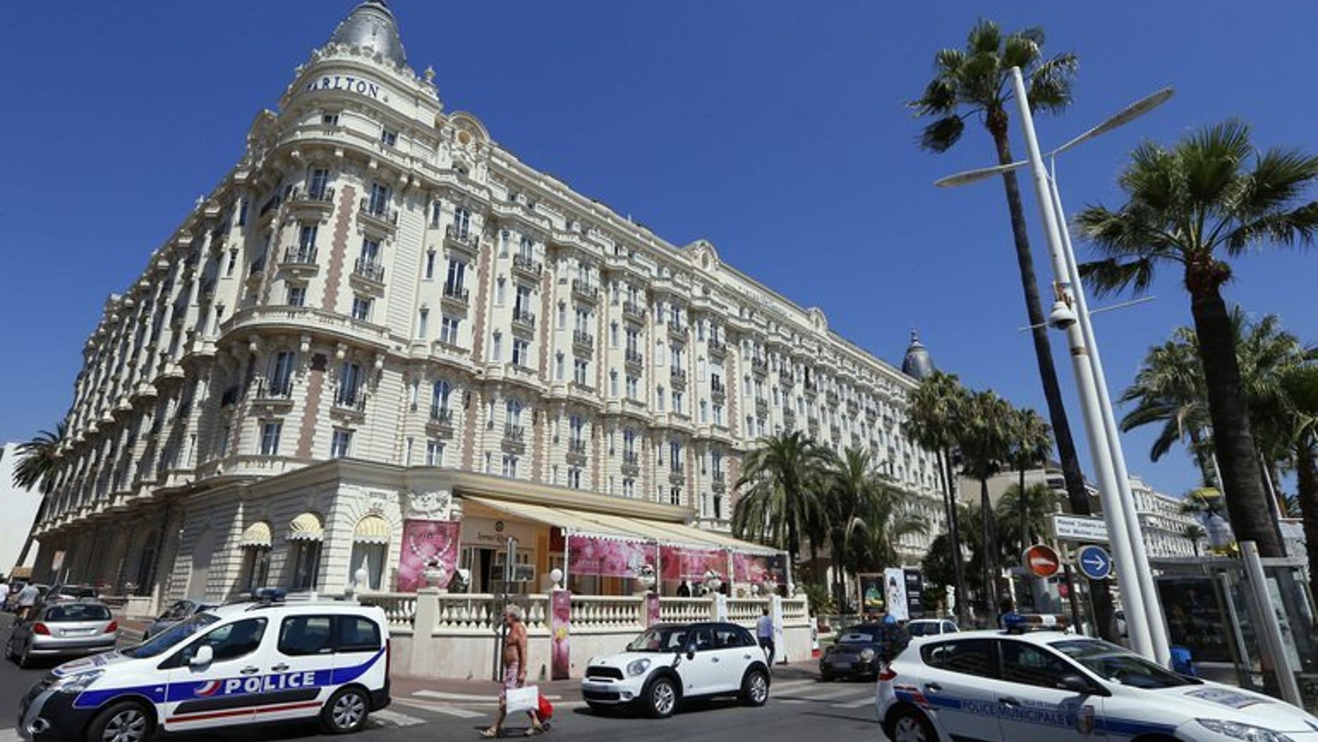 Police cars are parked outside the Carlton Hotel on July 28, 2013 in the French Riviera resort of Cannes, after an armed man held up a jewellery exhibition. Two armed men have held up a store selling luxury watches in the French Riviera resort of Cannes Wednesday, three days after a huge jewellery heist took place at a nearby hotel, a source close to the case said.