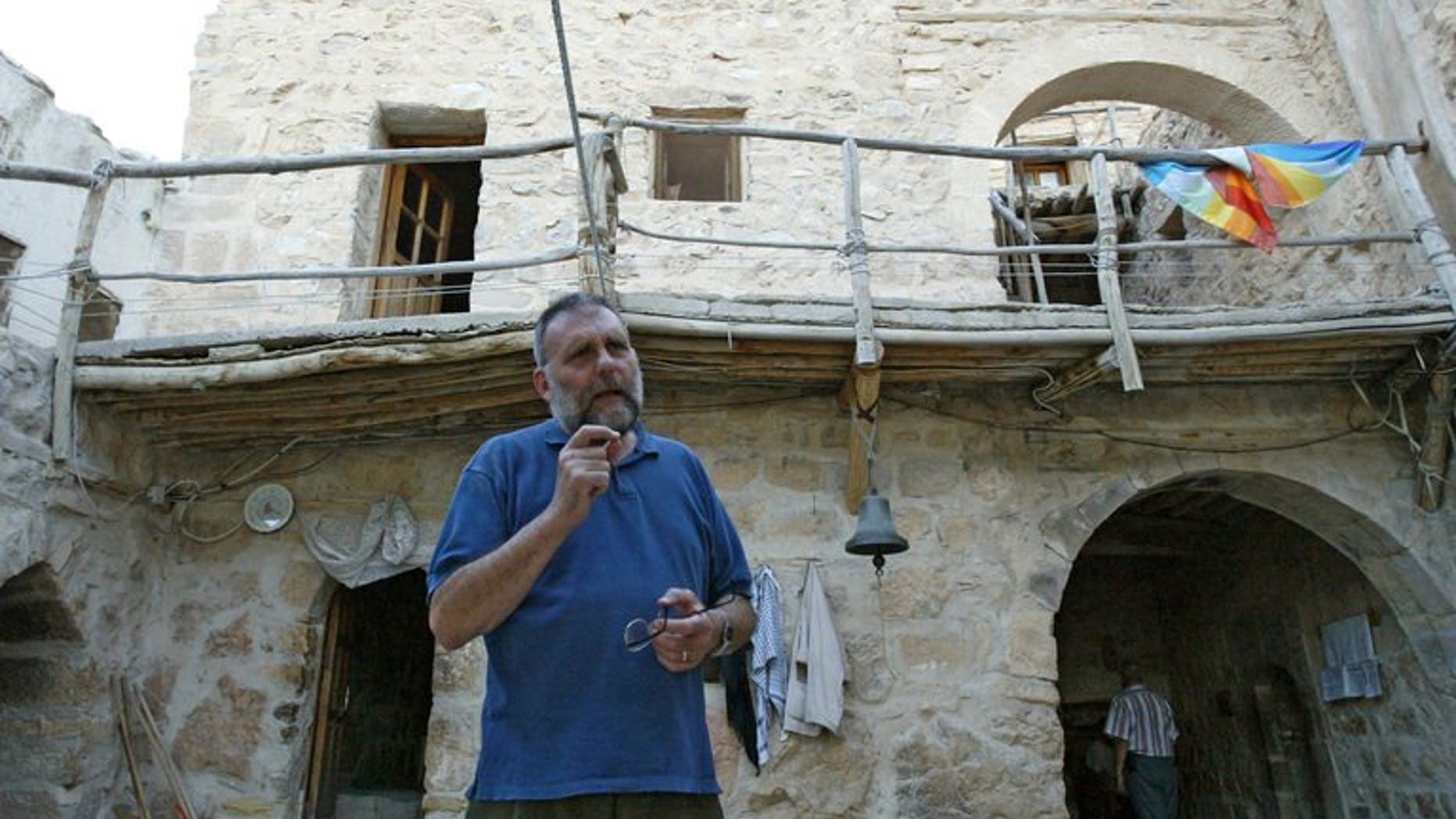 Father Paolo Dall'Oglio stands in a courtyard and talks to a visitor at Syria's historic Monastery of Mar Moussa, on July 11, 2007. Pope Francis has voiced concern over the fate of an Italian Jesuit priest missing in Syria.