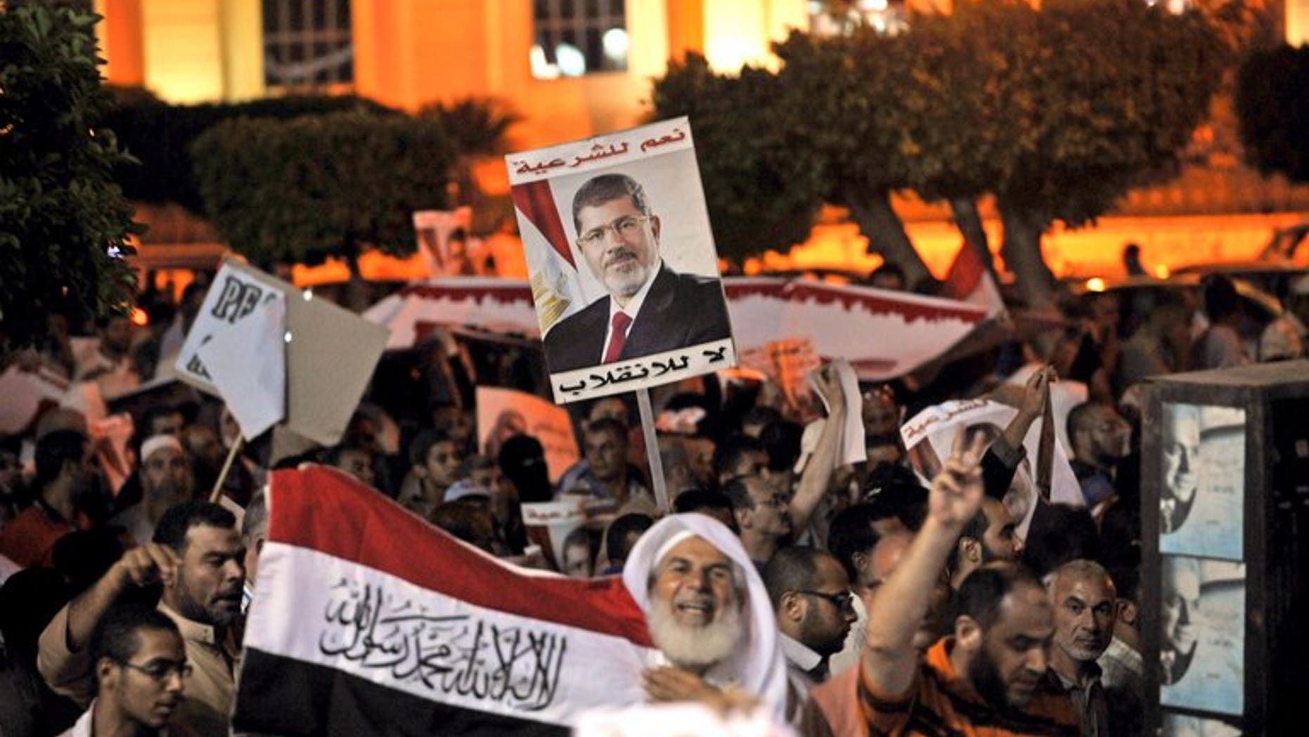 Egyptian supporters of Mohamed Morsi hold his portrait during a demonstration against the government in Cairo, on July 31, 2013. Egypt's cabinet have tasked police to take "necessary measures" to end protests by supporters of ousted president Mohamed Morsi, terming them a national security threat.