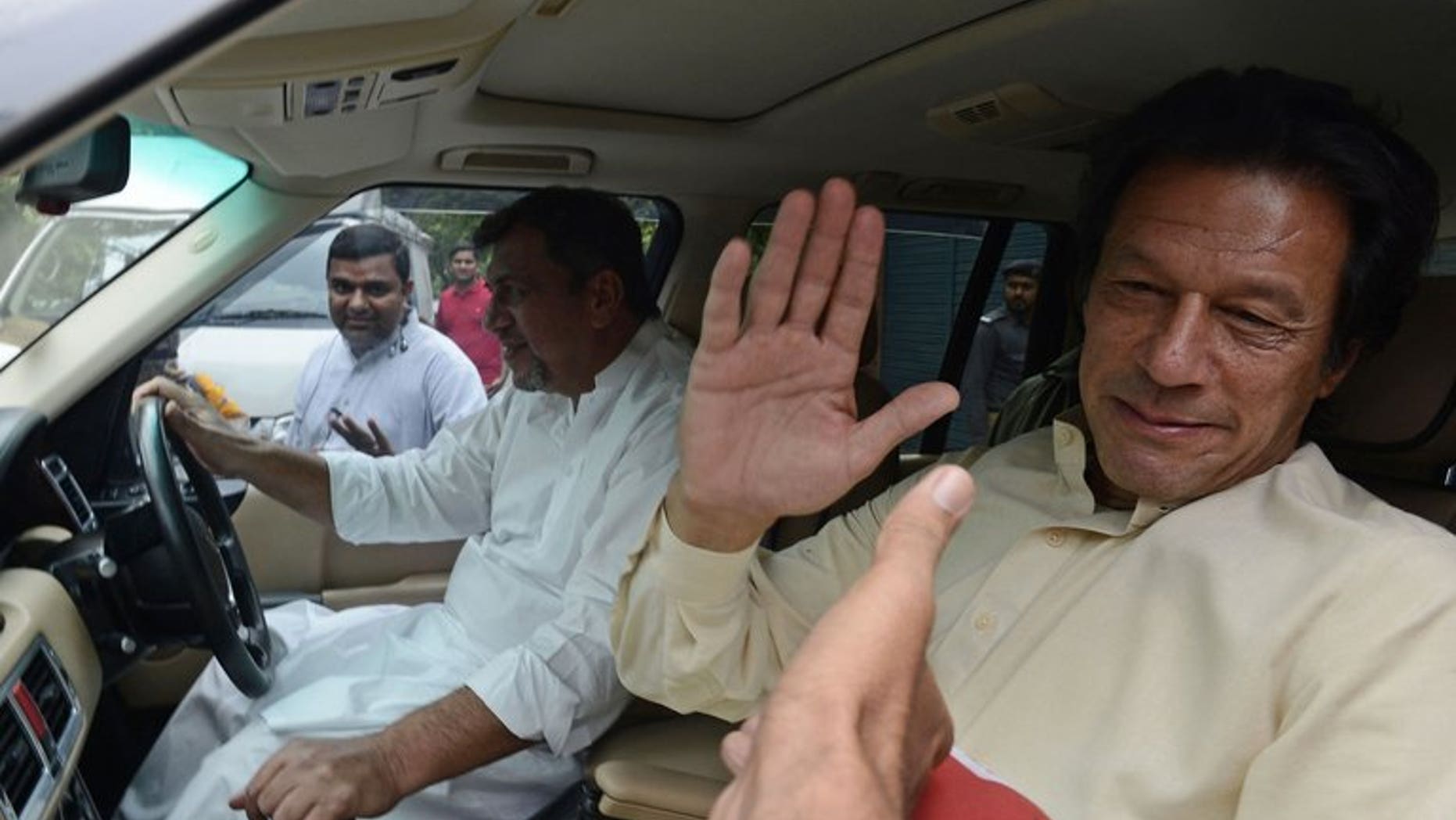 Pakistan Tehreek-e-Insaf (PTI) chairman Imran Khan greets supporters in Lahore on June 13, 2013. Pakistan's top court on Wednesday summoned cricketer-turned-politician Khan for a contempt hearing over his "critical and derogatory" remarks against the judiciary, a statement said.